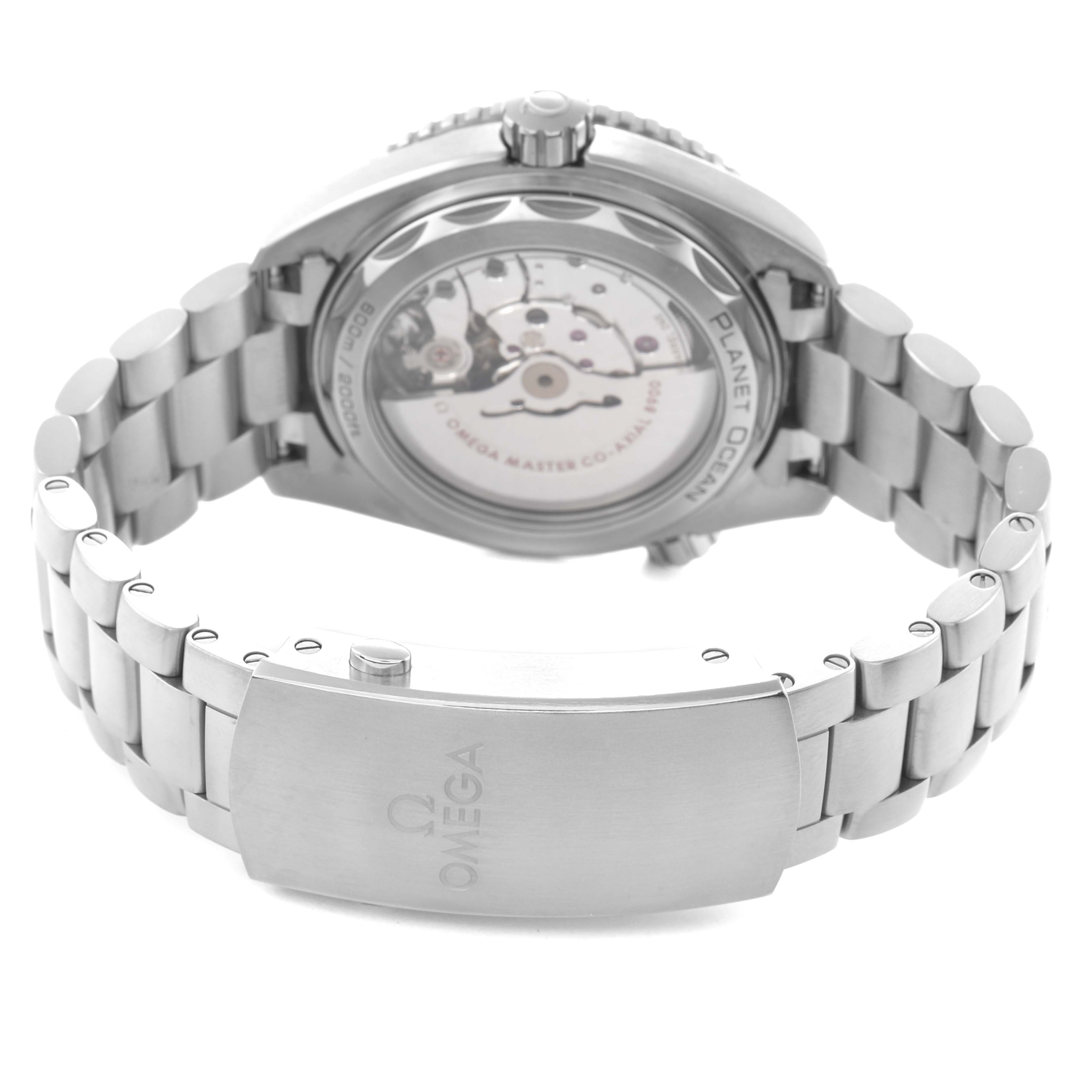 The watch is shown from the back, highlighting the transparent case back and metal bracelet, showcasing the movement of the Omega Planet Ocean model 215.90.44.21.99.001.