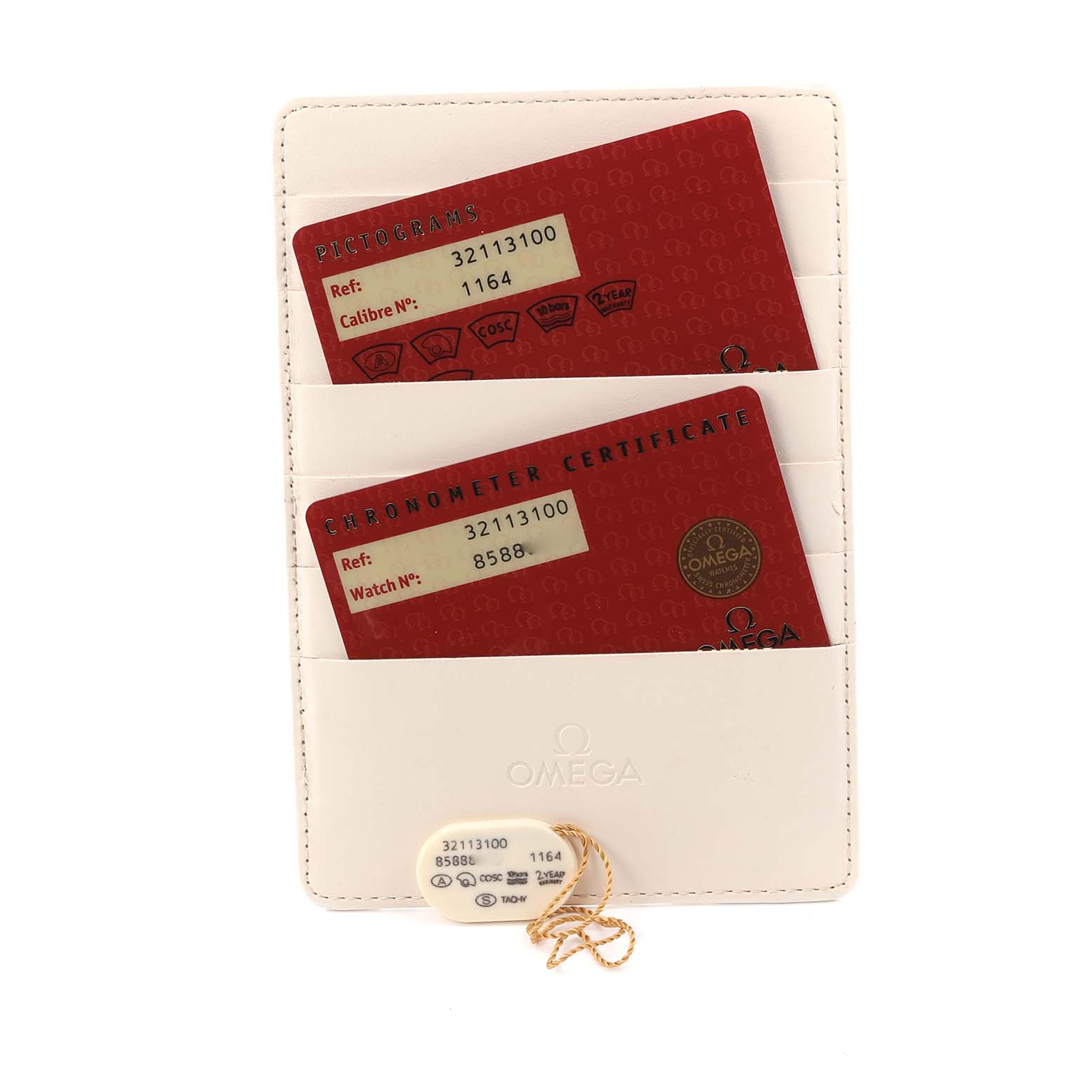 The image shows Omega Speedmaster model 3211.31.00 accessories, including pictogram and chronometer certificate cards, and a tag, viewed from above.