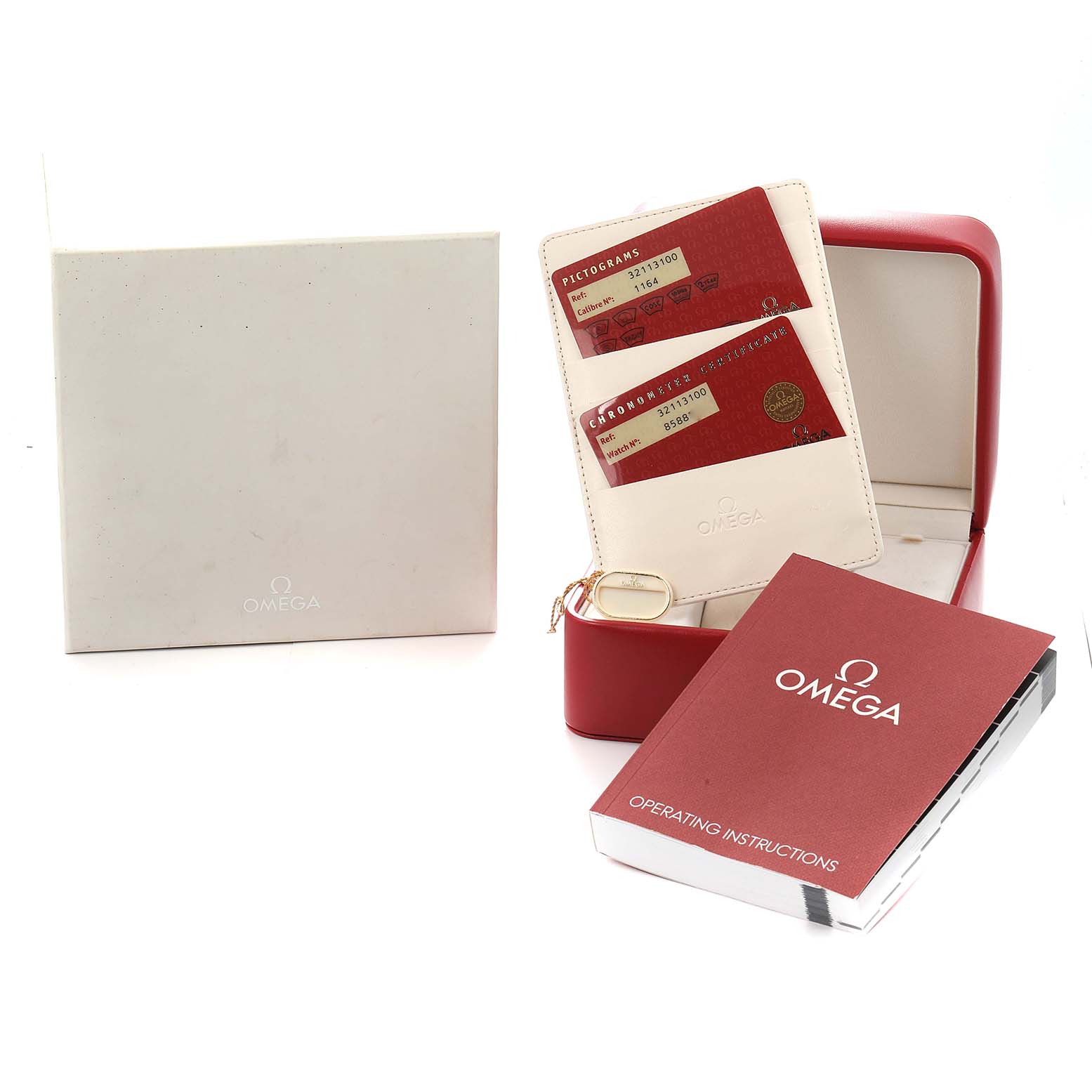 The image shows the packaging and accessories for an Omega Speedmaster model 3211.31.00, including the box, operating instructions, and warranty cards.