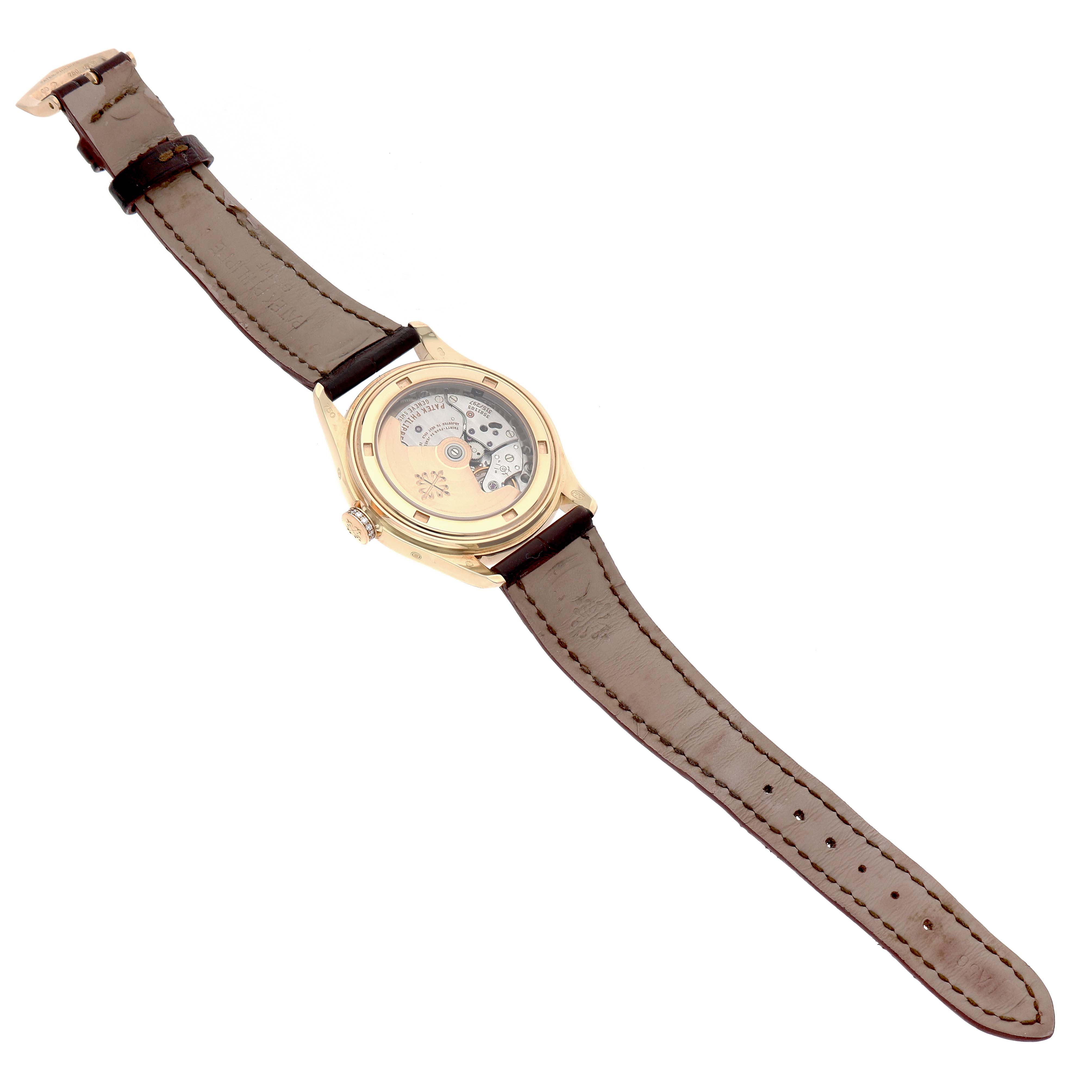 The Patek Philippe Complications 4936J-001 Men's Yellow Gold Mother of Pearl Dial watch is shown from a top-down angle, displaying its back case and leather strap.