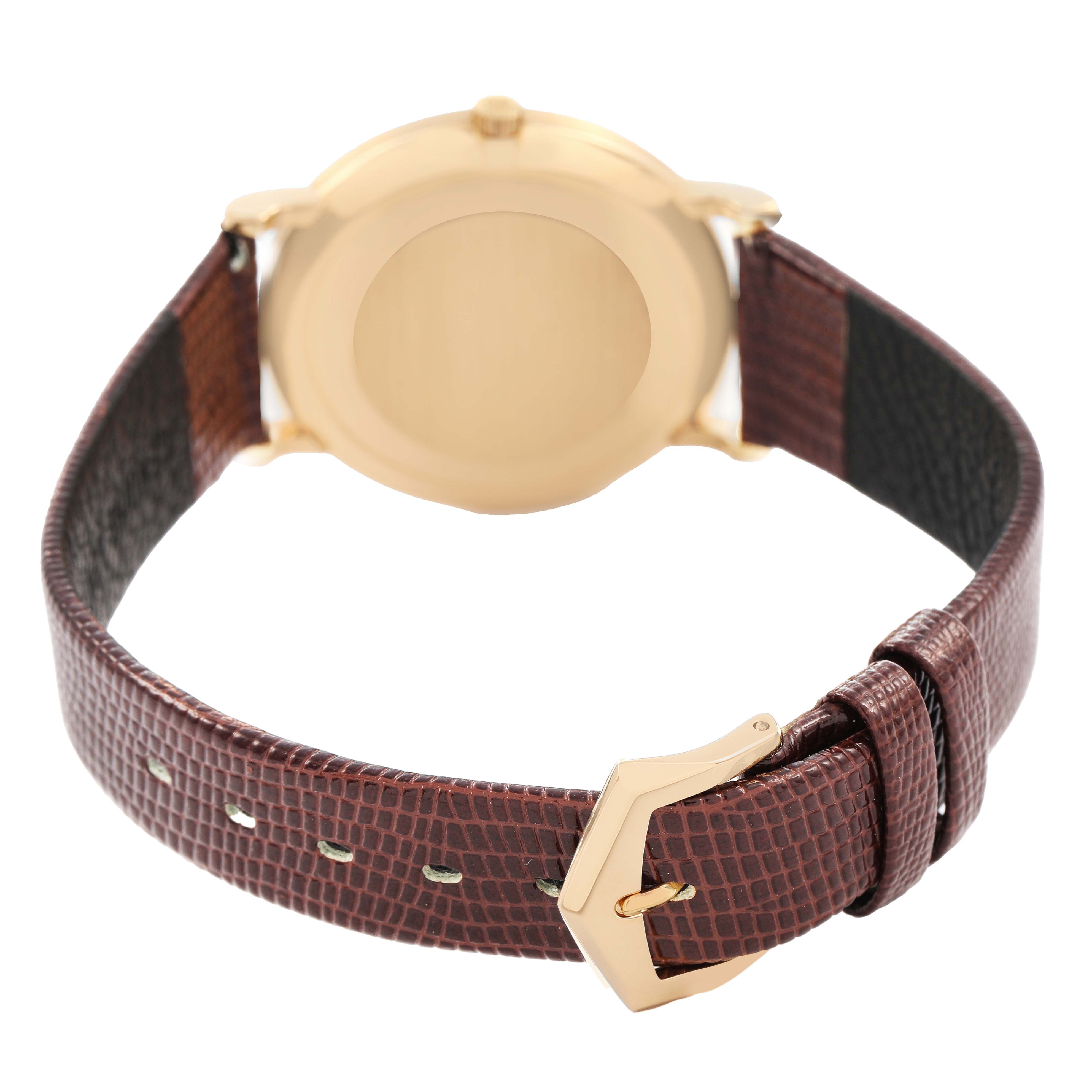 The image shows the back of a Patek Philippe Calatrava 3919J Men's Yellow Gold White Dial watch, featuring the case and brown leather strap with a gold buckle.