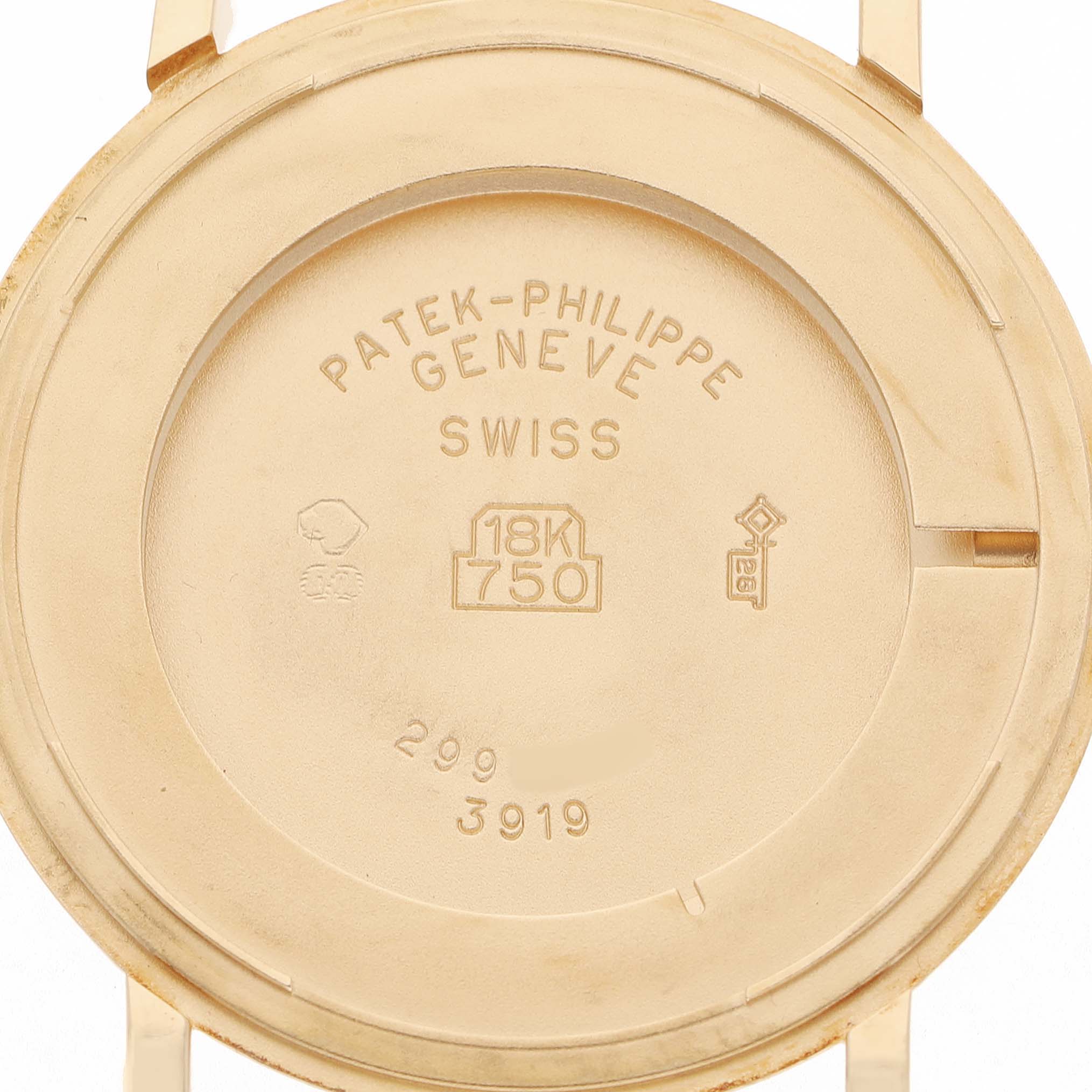 The image shows the case back of a Patek Philippe Calatrava 3919J Men's Yellow Gold White Dial watch from a close-up angle, highlighting engravings and markings.