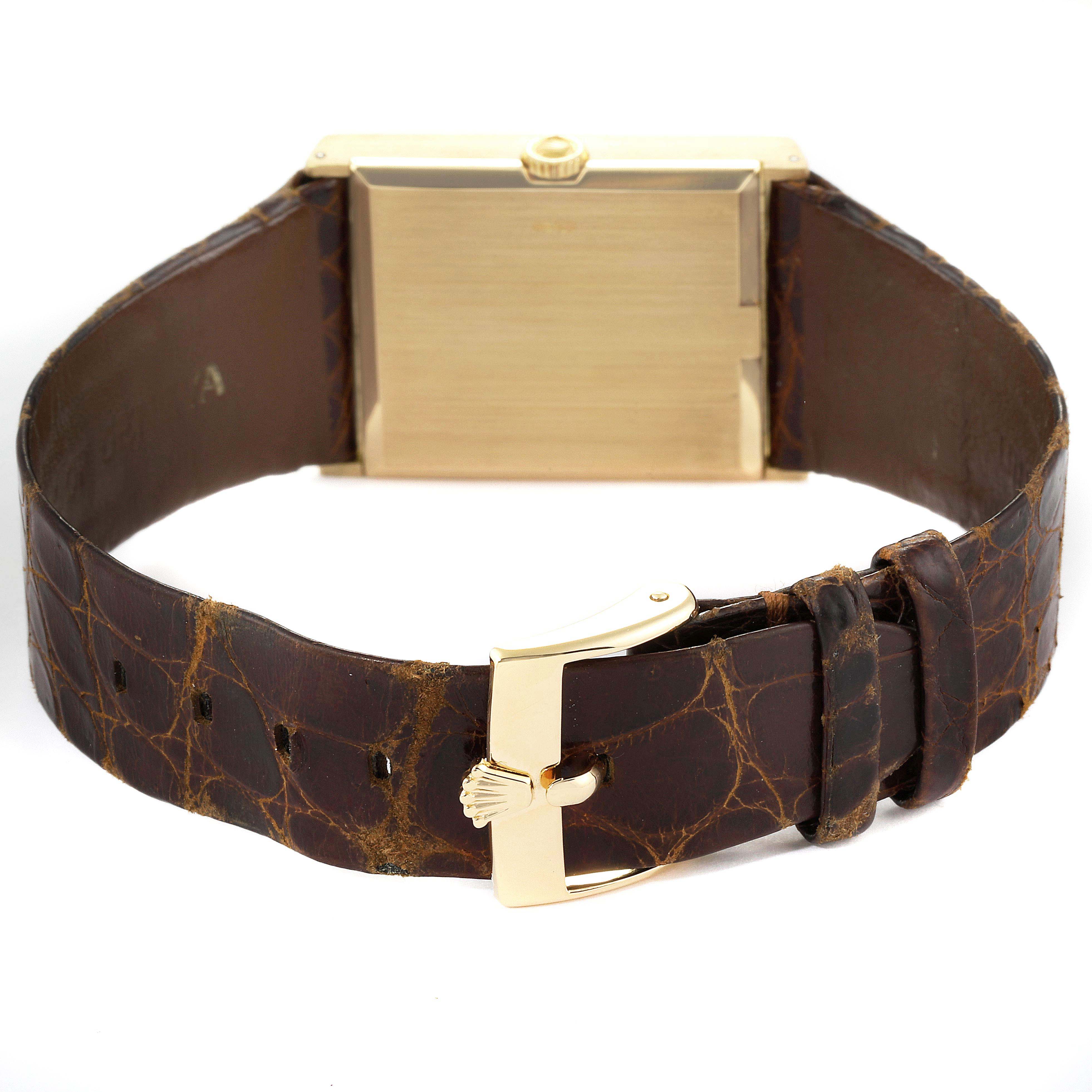 The image shows the back view of a Rolex Cellini 4127 Men's Yellow Gold Brown Dial 4127 Men's Yellow Gold Brown Dial watch, highlighting its case, crown, and leather strap with a gold buckle.