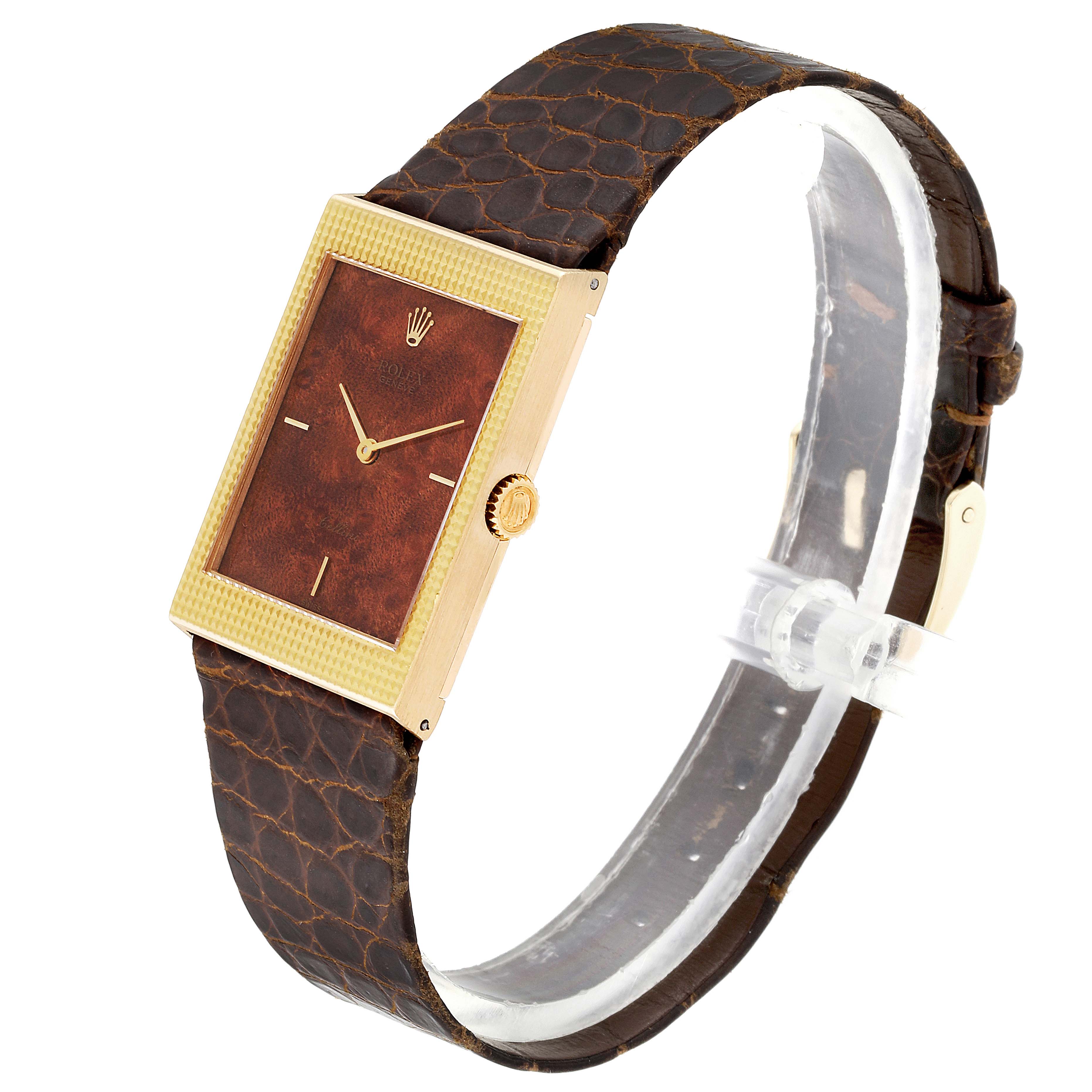 The Rolex Cellini 4127 Men's Yellow Gold Brown Dial 4127 Men's Yellow Gold Brown Dial watch is shown from an angled side perspective, highlighting its brown leather strap and rectangular face.
