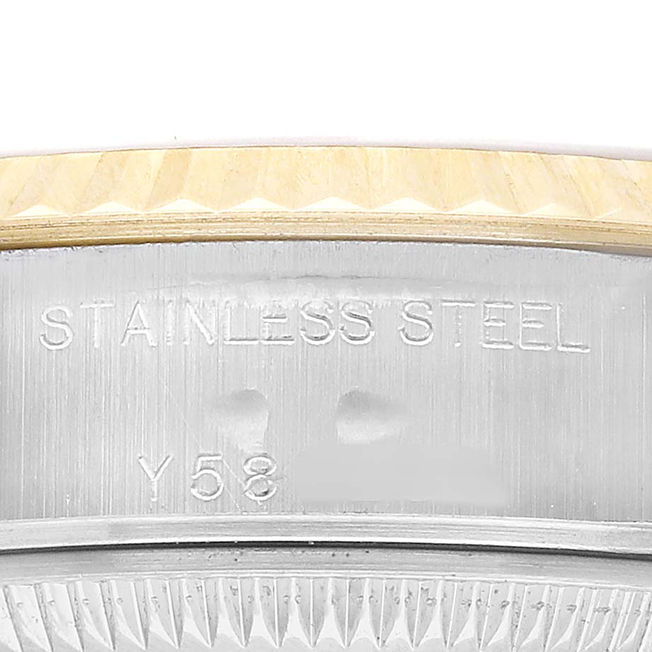 The image shows a close-up of the Rolex Datejust 79173 Women's Stainless Steel White Dial's stainless steel and gold bezel with engraved details.