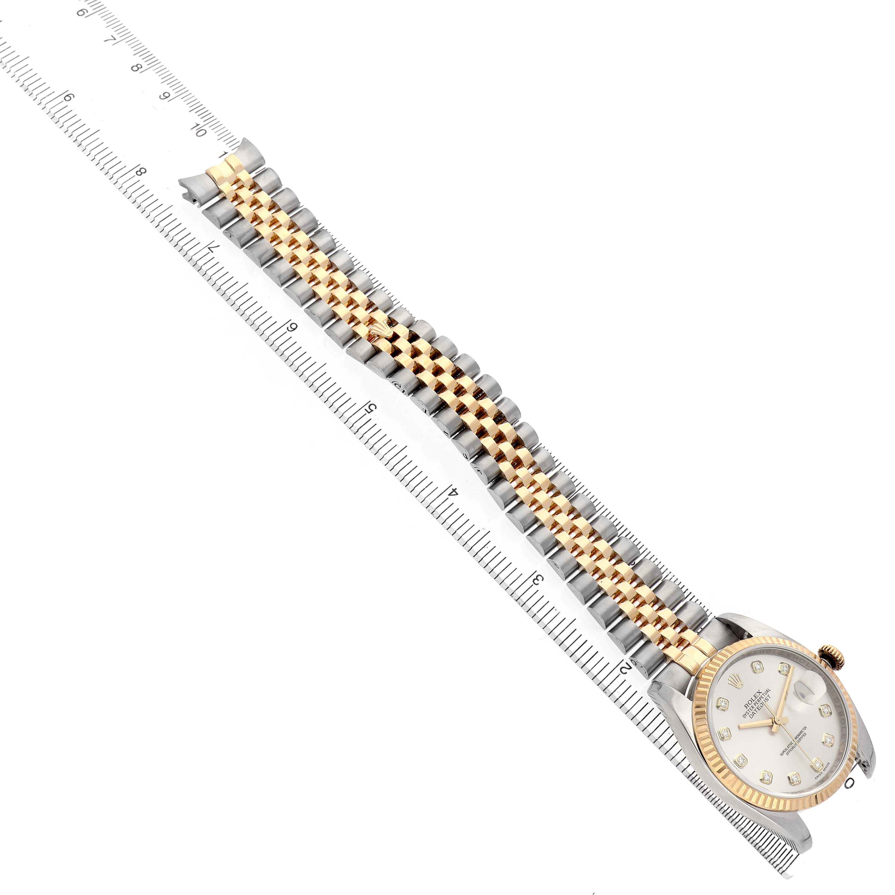The Rolex Datejust 116233 Men's Stainless Steel Silver Dial watch is shown at an oblique angle, displaying the bracelet, case, and bezel alongside a ruler for scale.