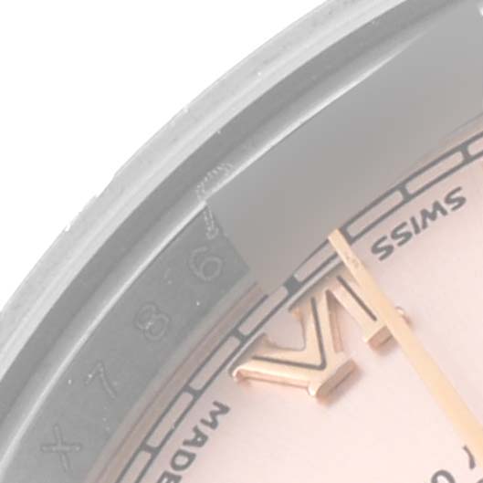 This close-up of a Rolex Datejust 179171 Women's Steel and Gold (two tone) Pink Dial 179171 Women's Steel and Gold (two tone) Pink Dial watch shows a portion of the dial with the Roman numeral VI and surrounding text.