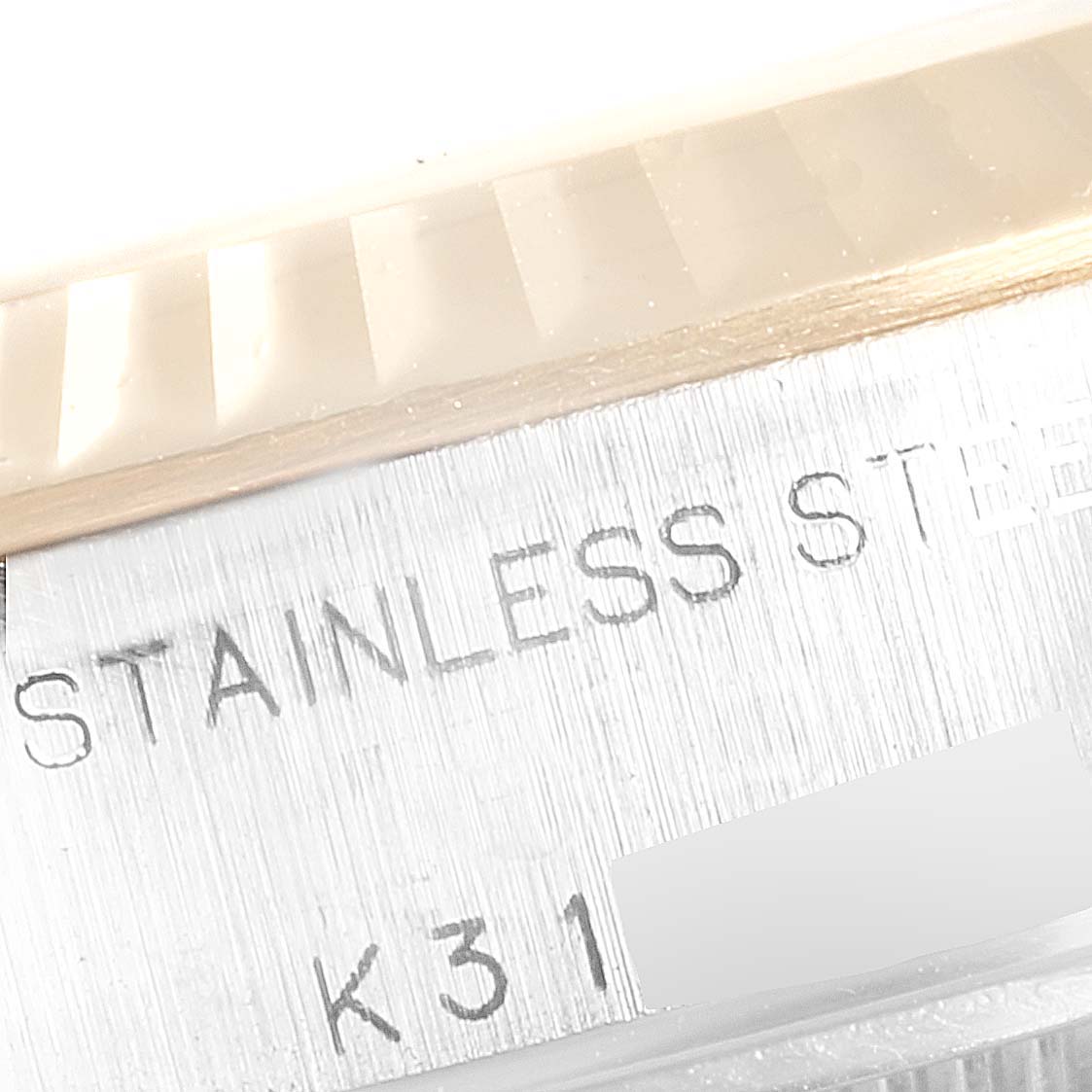 This close-up image shows the fluted bezel and part of the stainless steel case of a Rolex Datejust 79173 Women's Steel and Gold (two tone) Silver Dial 79173 Women's Steel and Gold (two tone) Silver Dial watch.