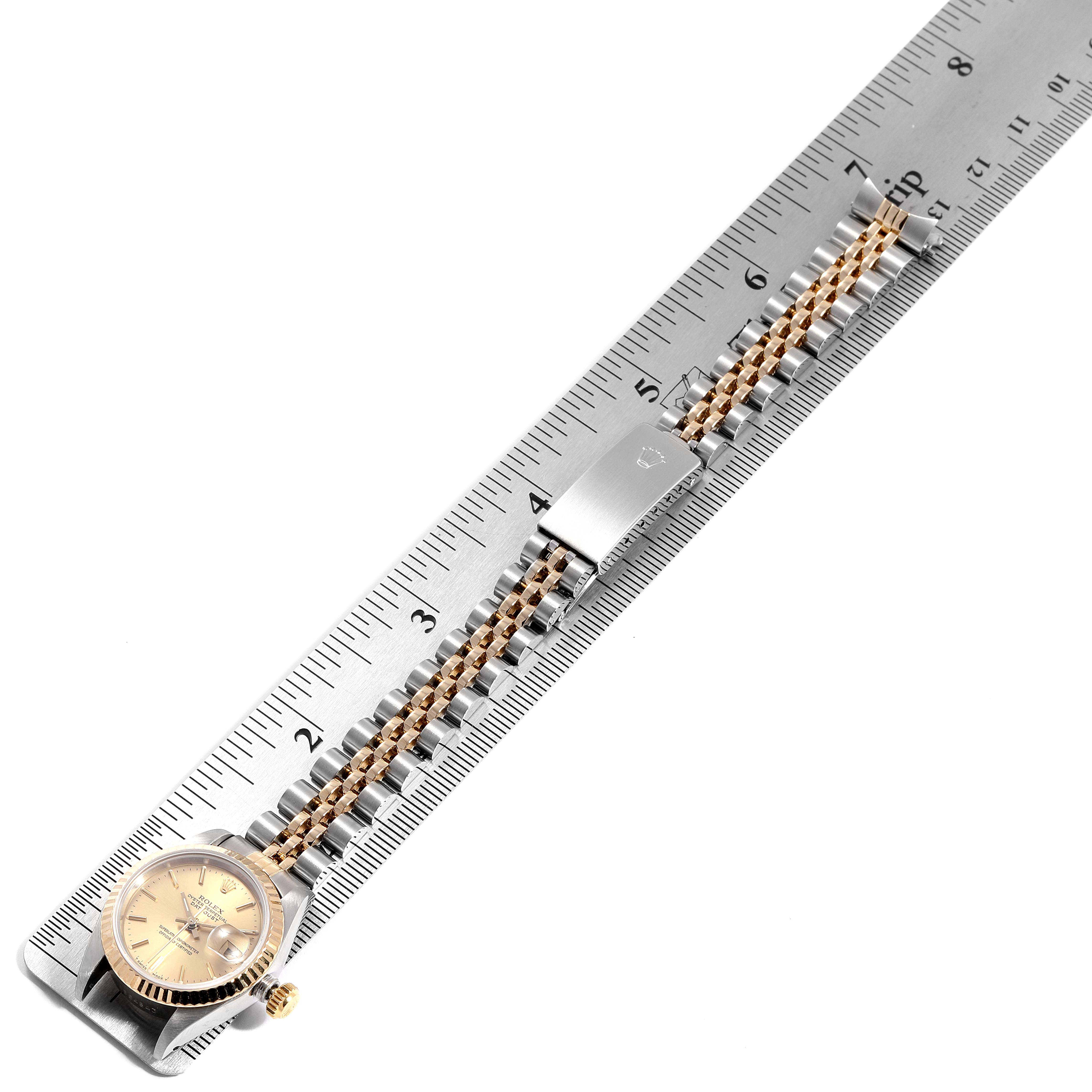 The Rolex Datejust 69173 Women's Steel and Gold (two tone) Champagne Dial 69173 Women's Steel and Gold (two tone) Champagne Dial watch is shown from an overhead angle, displaying the dial, bracelet, and clasp alongside a ruler for scale.