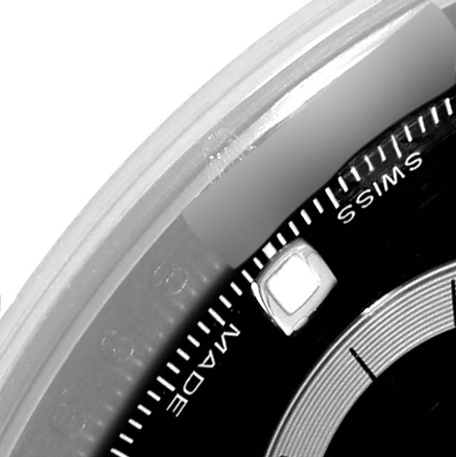 This close-up of a Rolex Daytona 116520 Men's Stainless Steel Black Dial 116520 Men's Stainless Steel Black Dial watch shows a portion of the dial with "SWISS MADE" text and a luminescent hour marker.