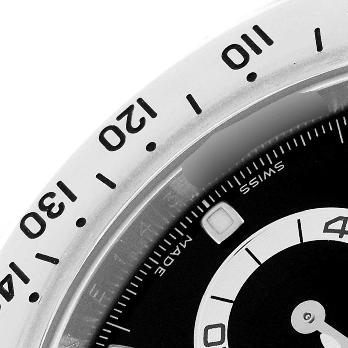 A close-up of the Rolex Daytona 116520 Men's Stainless Steel Black Dial 116520 Men's Stainless Steel Black Dial watch showing part of the bezel and dial from an angled perspective.