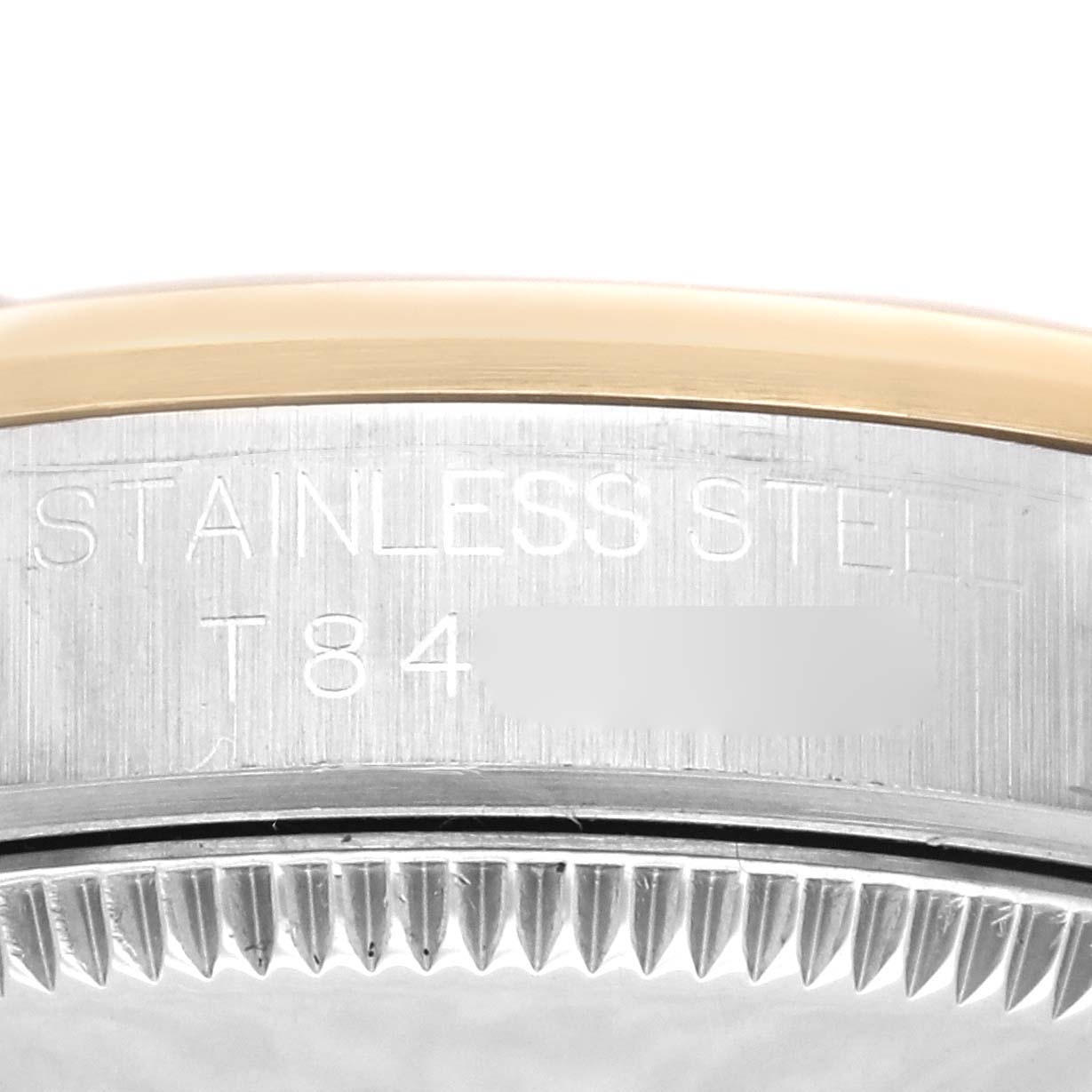 This image shows the engraved edge and part of the bezel of a mid-size model by Rolex, highlighting the stainless steel material.
