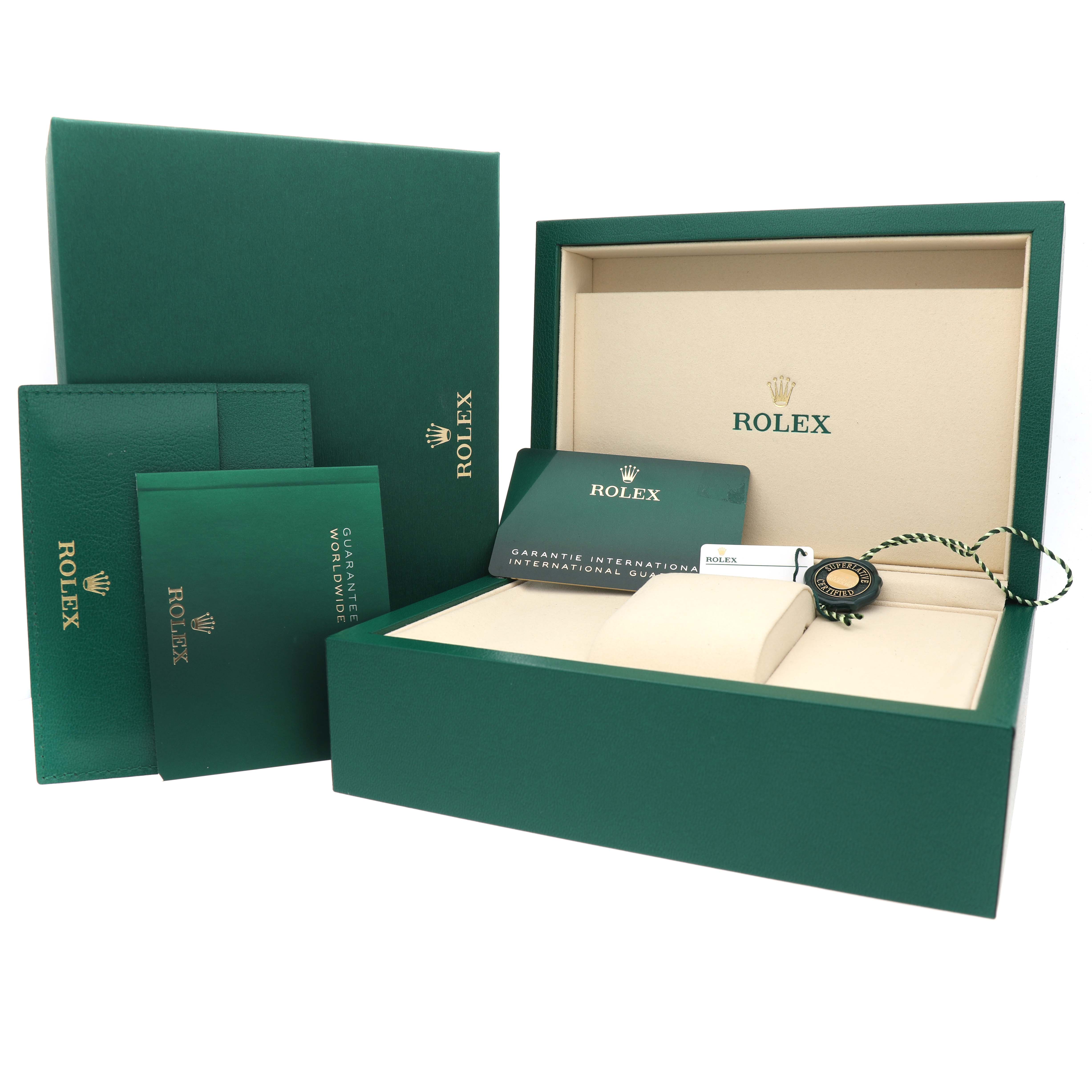 The image shows the packaging and accessories for a Rolex Oyster Perpetual 134300 Men's Stainless Steel Purple Dial, including boxes, booklets, and a tag, viewed from the front.