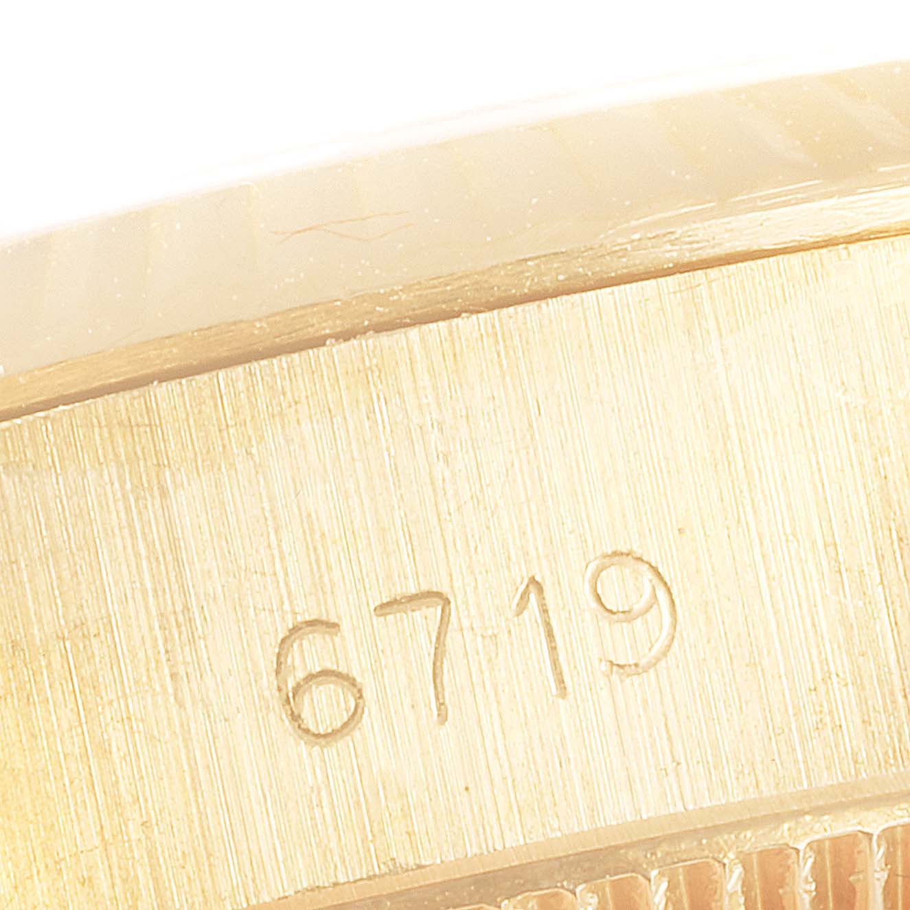 This image shows a close-up of the model number engraving (6719) on the side of the case of a Rolex Oyster Perpetual 6719 Women's Yellow Gold Silver Dial 6719 Women's Yellow Gold Silver Dial watch.