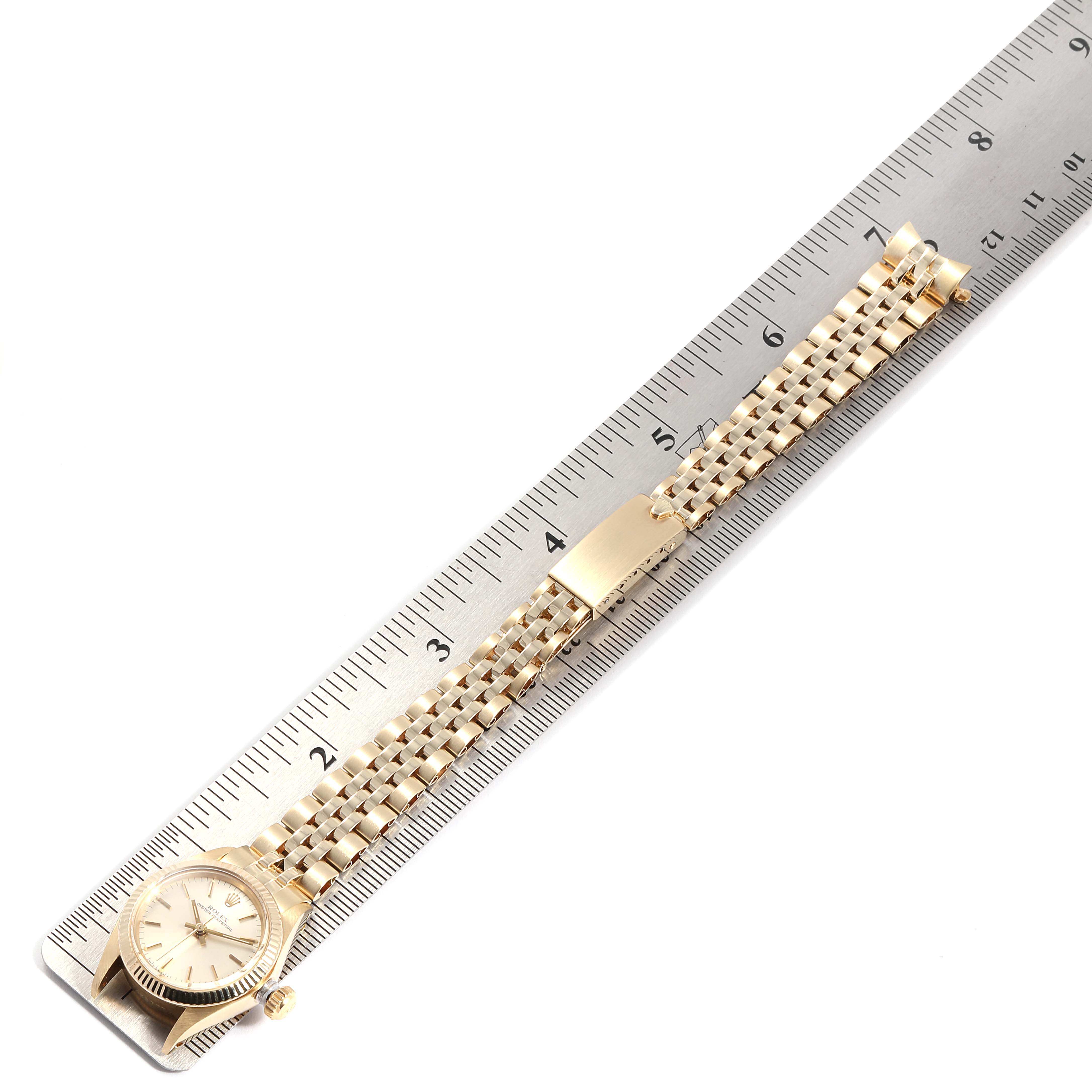 The Rolex Oyster Perpetual 6719 Women's Yellow Gold Silver Dial 6719 Women's Yellow Gold Silver Dial watch is shown from a top view, fully extended with a ruler for scale.