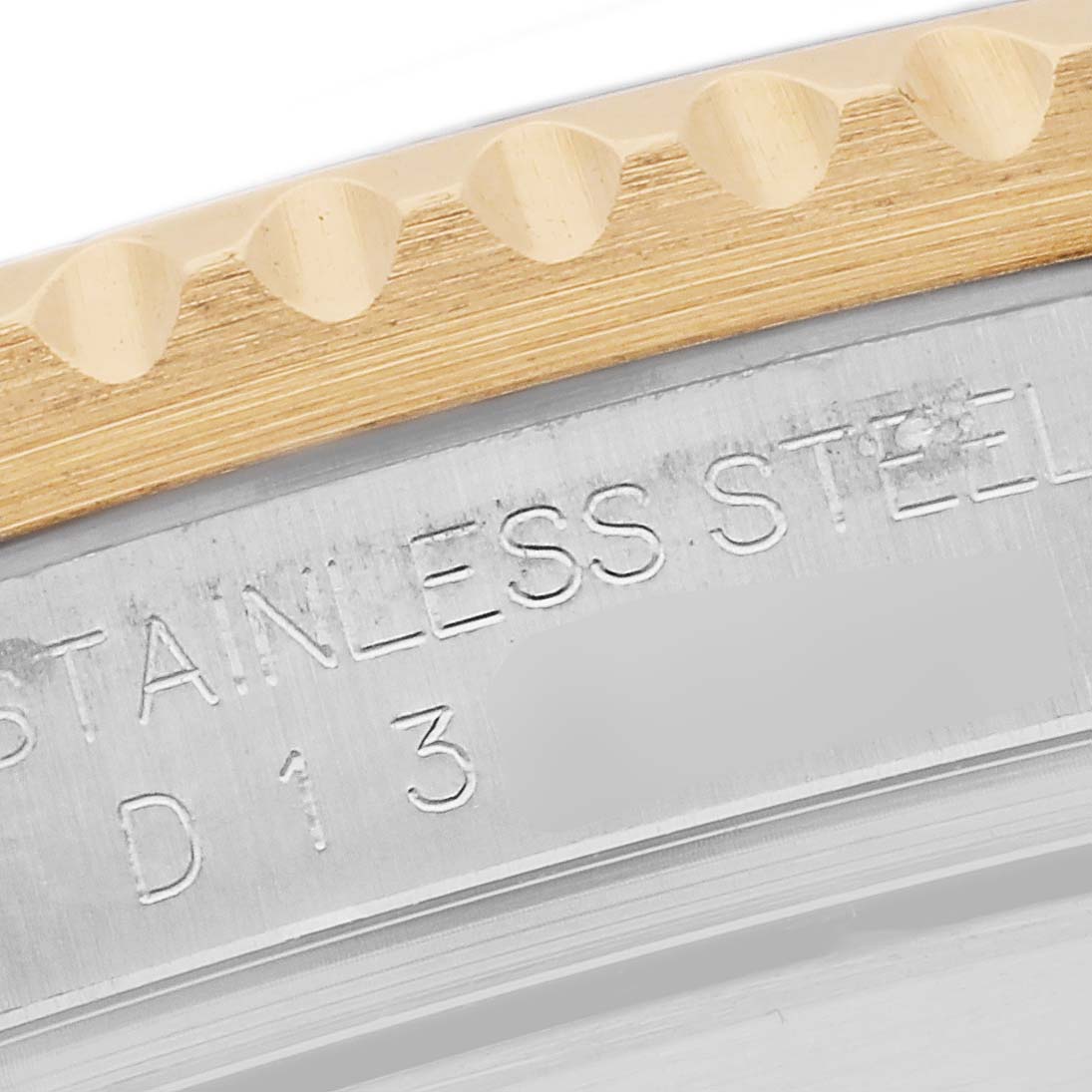 The image shows a close-up angle of the edge of the bezel and the engraved stainless steel case of a Rolex Submariner 16613 Men's Steel and Gold (two tone) Blue Dial 16613 Men's Steel and Gold (two tone) Blue Dial watch.