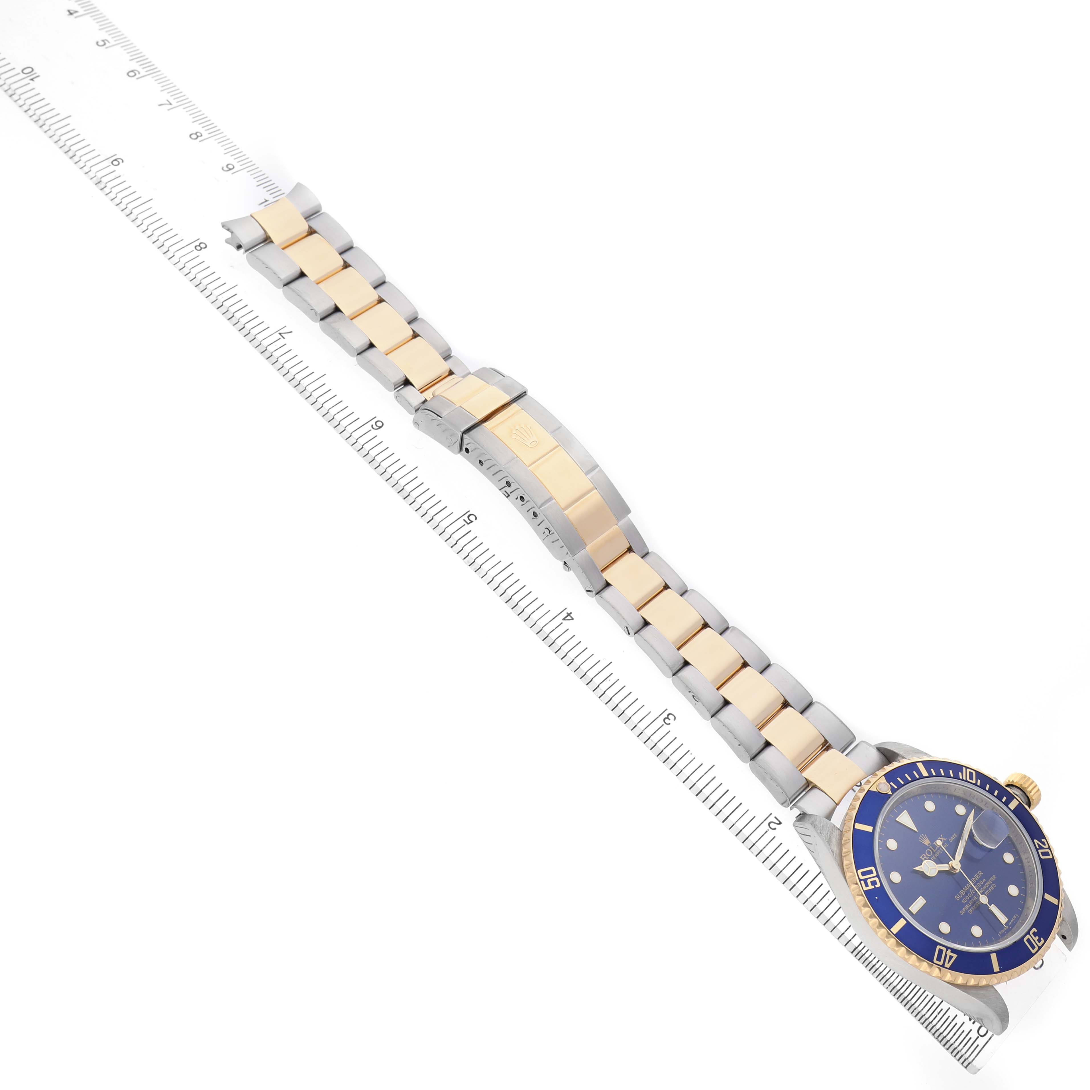 The image shows a side angle of a Rolex Submariner 16613 Men's Steel and Gold (two tone) Blue Dial, featuring the bracelet, clasp, and face with a blue bezel.