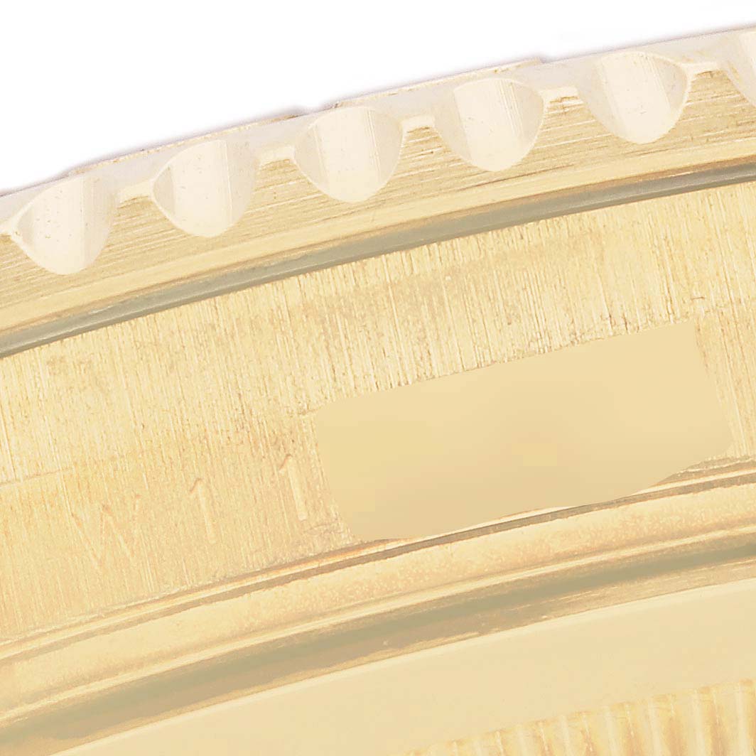 The image shows a close-up view of the etched crown and bezel teeth of a Rolex Yacht-Master 16628 Men's Yellow Gold White Dial 16628 Men's Yellow Gold White Dial watch.