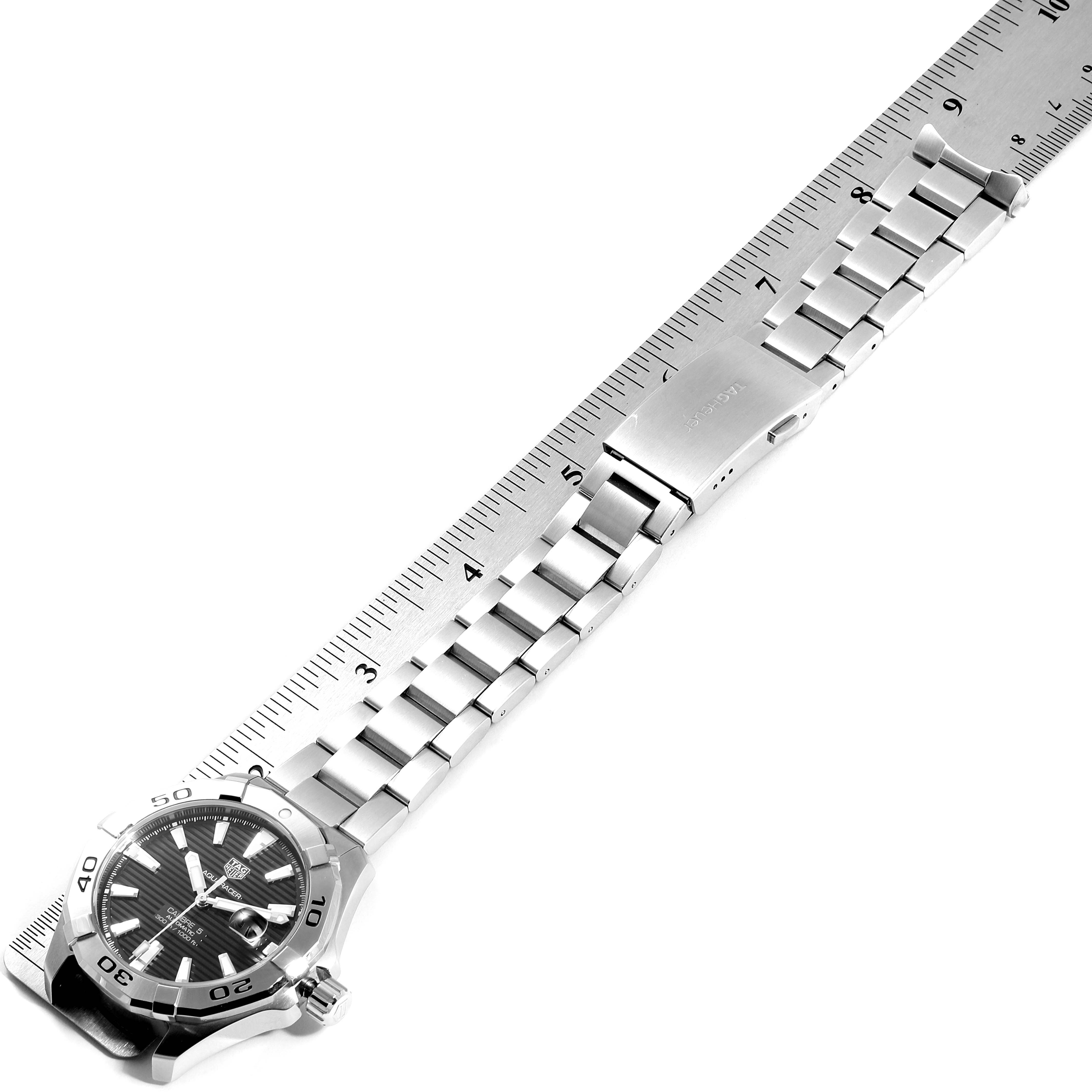 The image shows a partial view of a Tag Heuer Aquaracer WAY2010.BA0927 Men
s Stainless Steel Black Dial WAY2010.BA0927 Men
s Stainless Steel Black Dial watch, with a focus on the bracelet and clasp, aligned with a ruler for measurement.