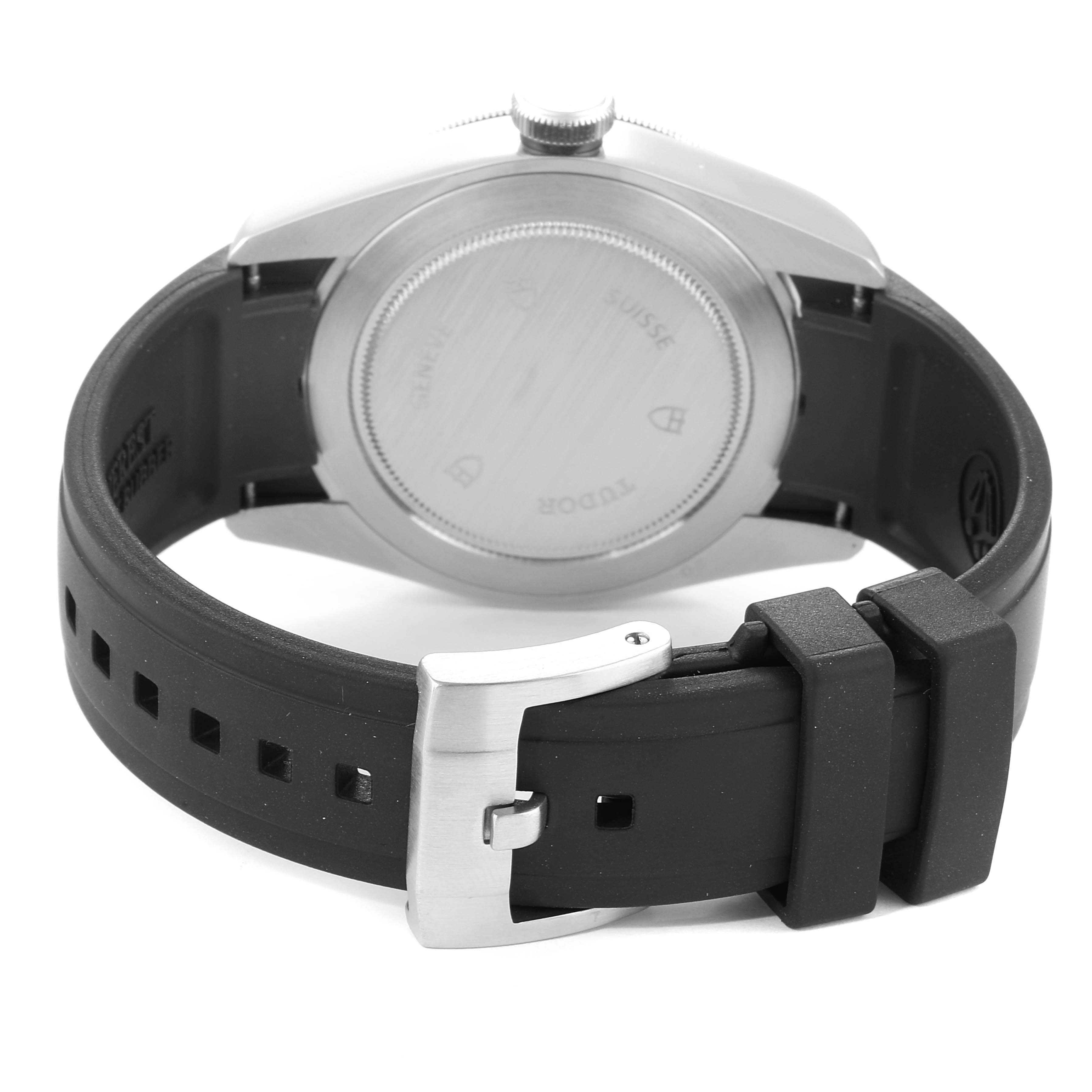 The image shows the rear view of the Tudor Heritage Black Bay 79220 Men
s Stainless Steel Black Dial 79220 Men
s Stainless Steel Black Dial watch, focusing on the case back and a black rubber strap with a stainless steel buckle.