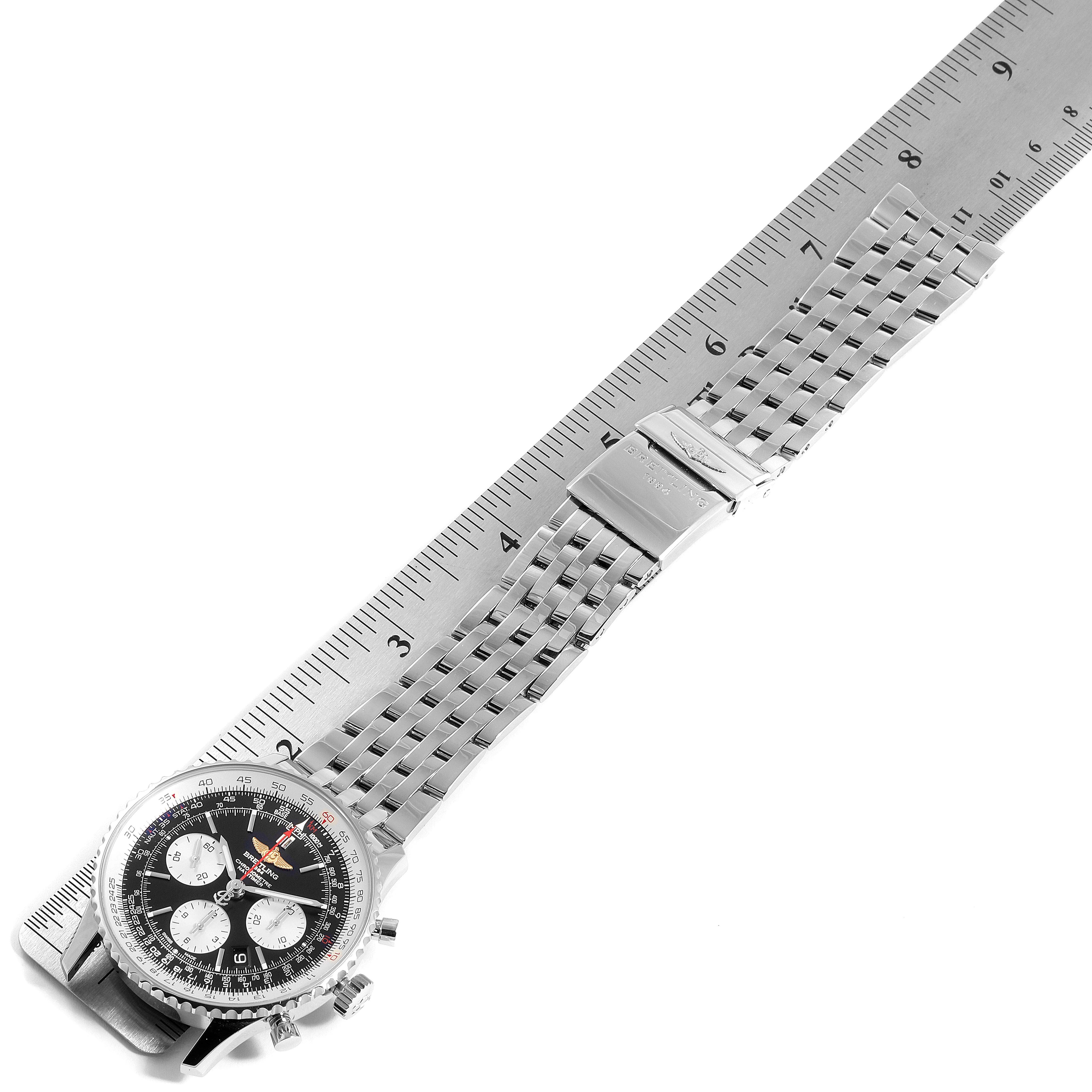 The Breitling Navitimer AB012721-BD09-453A Men
s Stainless Steel Black Dial AB012721-BD09-453A Men
s Stainless Steel Black Dial watch is shown from a top-down angle, displaying its face and metal strap alongside a ruler for scale.