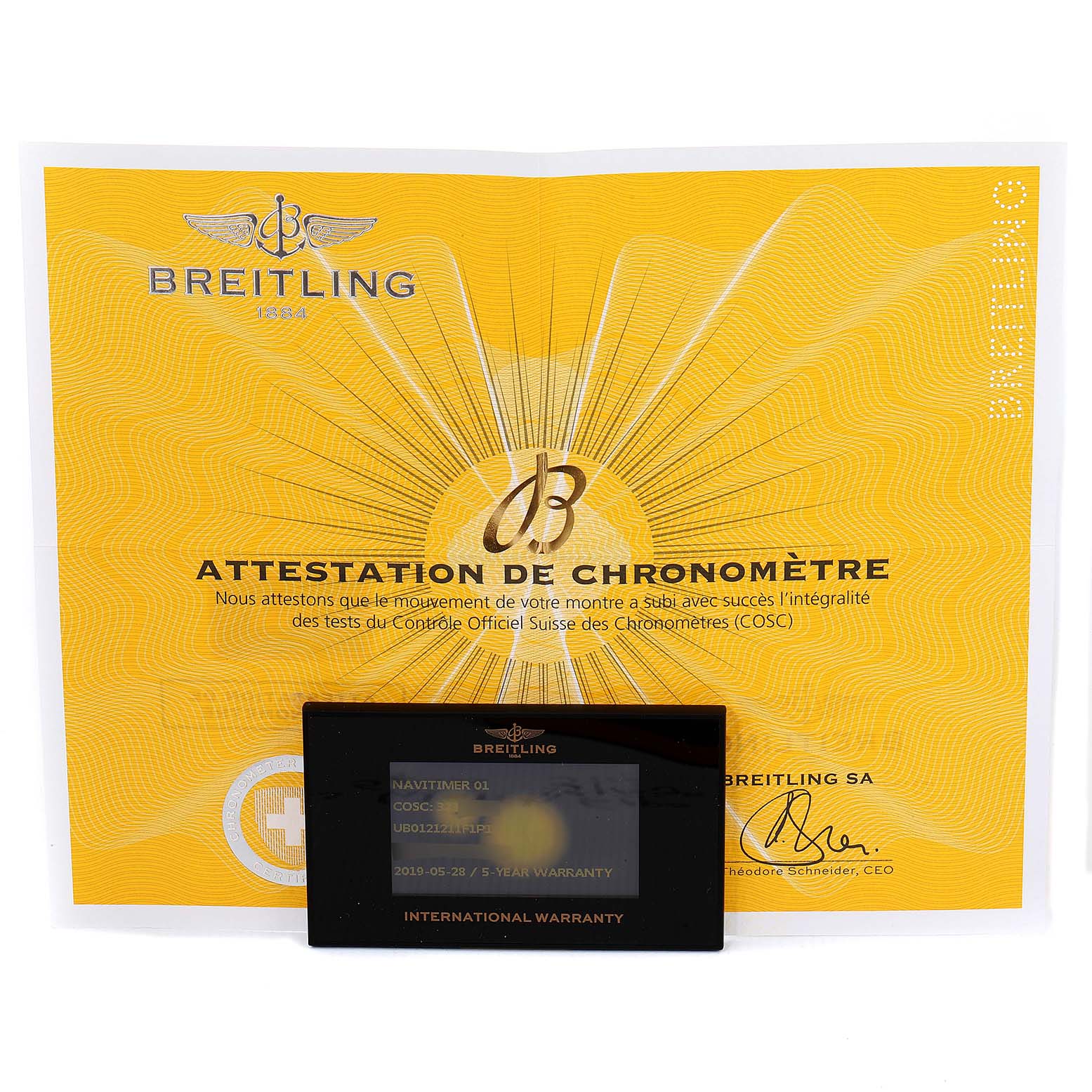 The image shows a yellow attestation certificate and an international warranty card for the Breitling Navitimer UB012121-F582-743P Men's Steel and Gold (two tone) Grey Dial UB012121-F582-743P Men's Steel and Gold (two tone) Grey Dial model.
