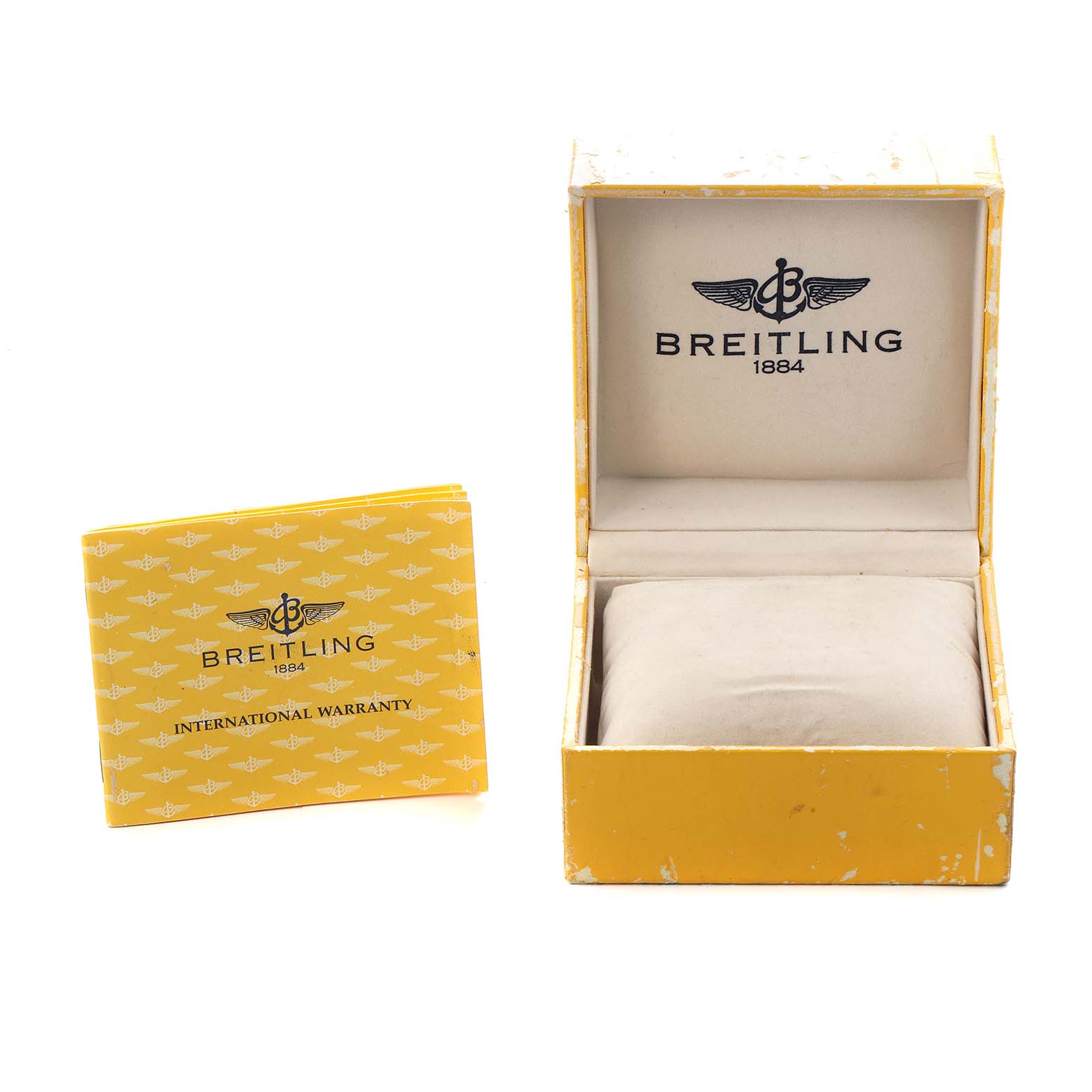The image shows a Breitling Navitimer D13022 Men
s Steel and Gold (two tone) Black Dial watch box open with an international warranty booklet beside it.