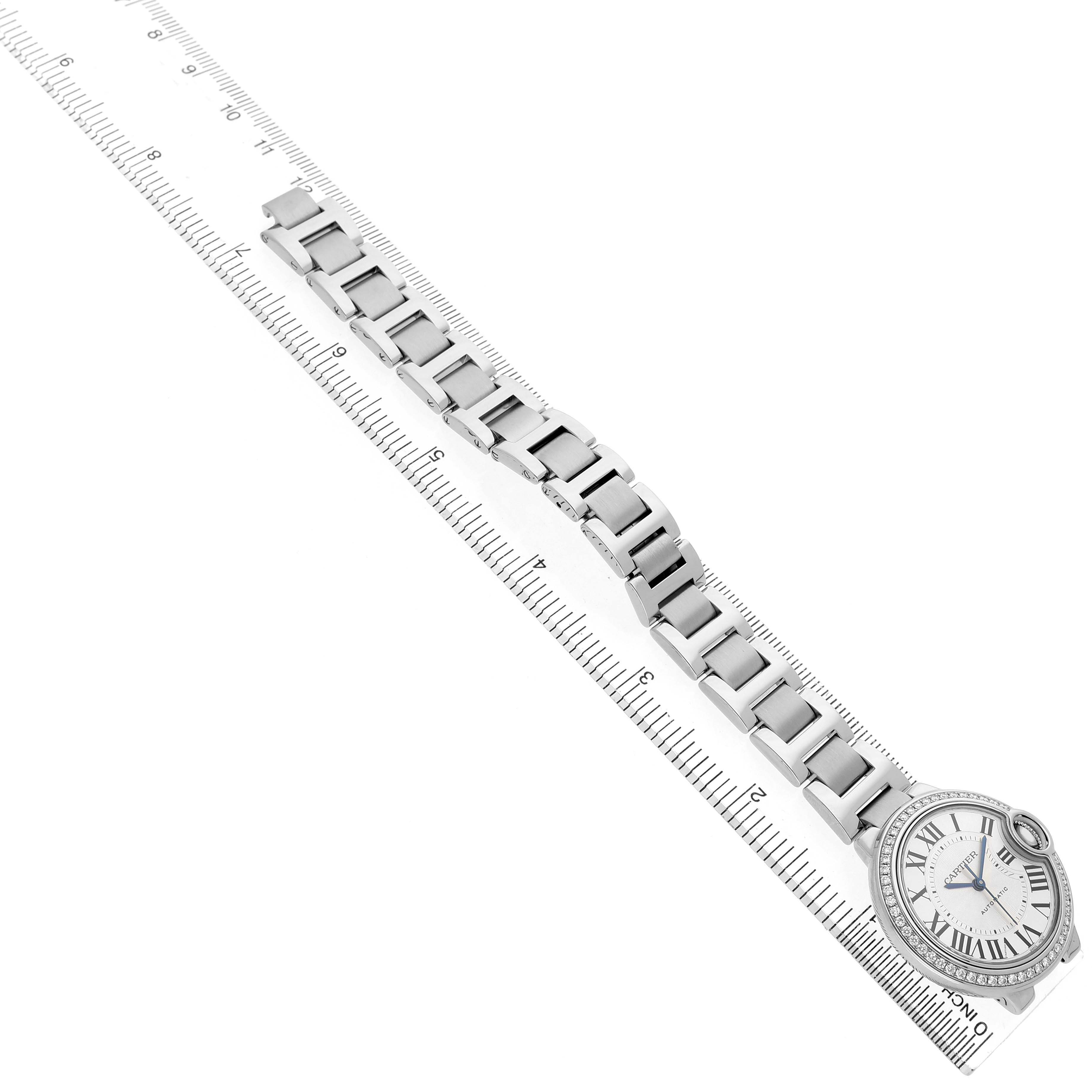The image shows a top-down view of a Cartier Ballon Bleu W4BB0016 Women's Stainless Steel Silver Dial watch, highlighting the face and the full length of the metal strap.