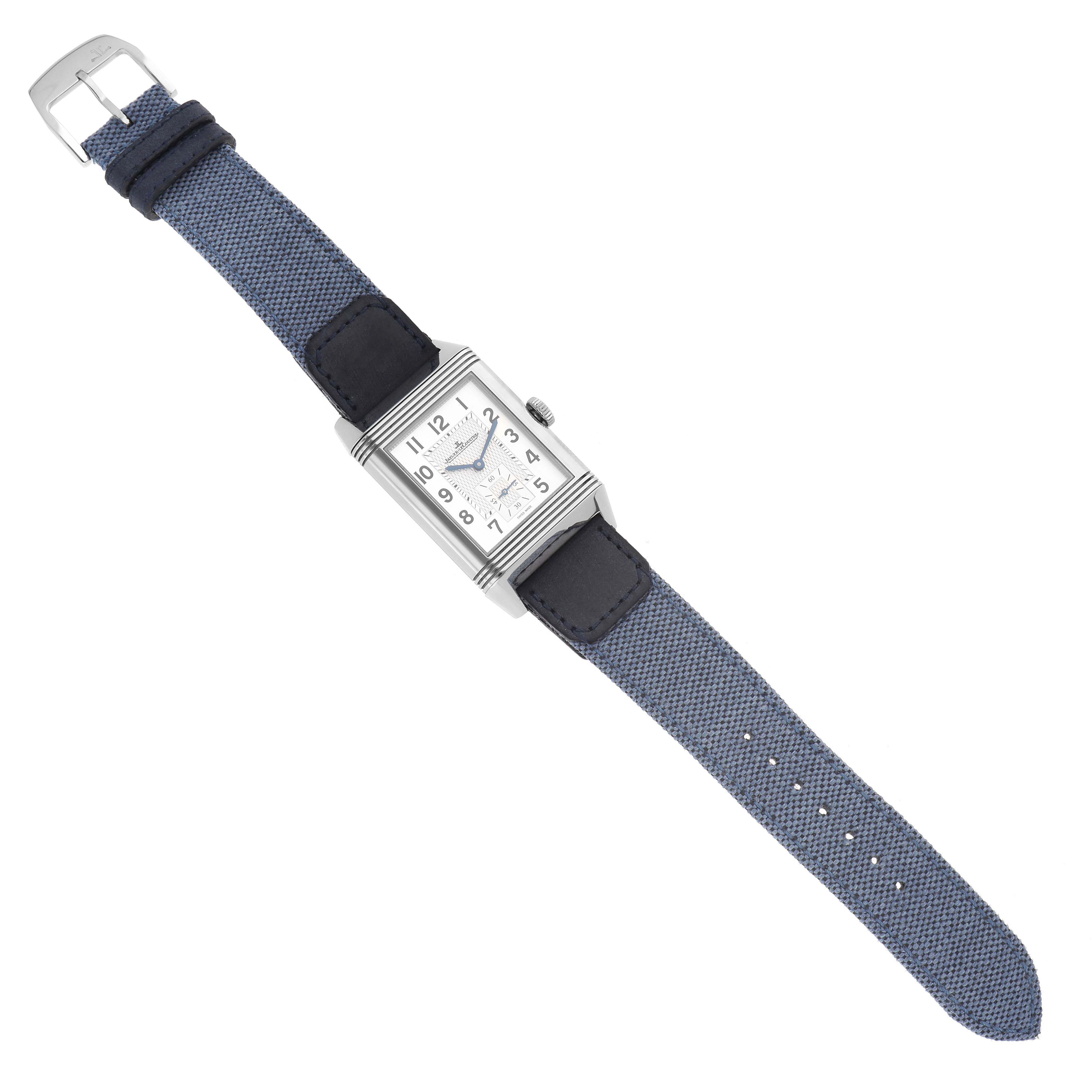 The Jaeger-LeCoultre Reverso watch is shown from above, displaying its face, case, crown, and blue strap.