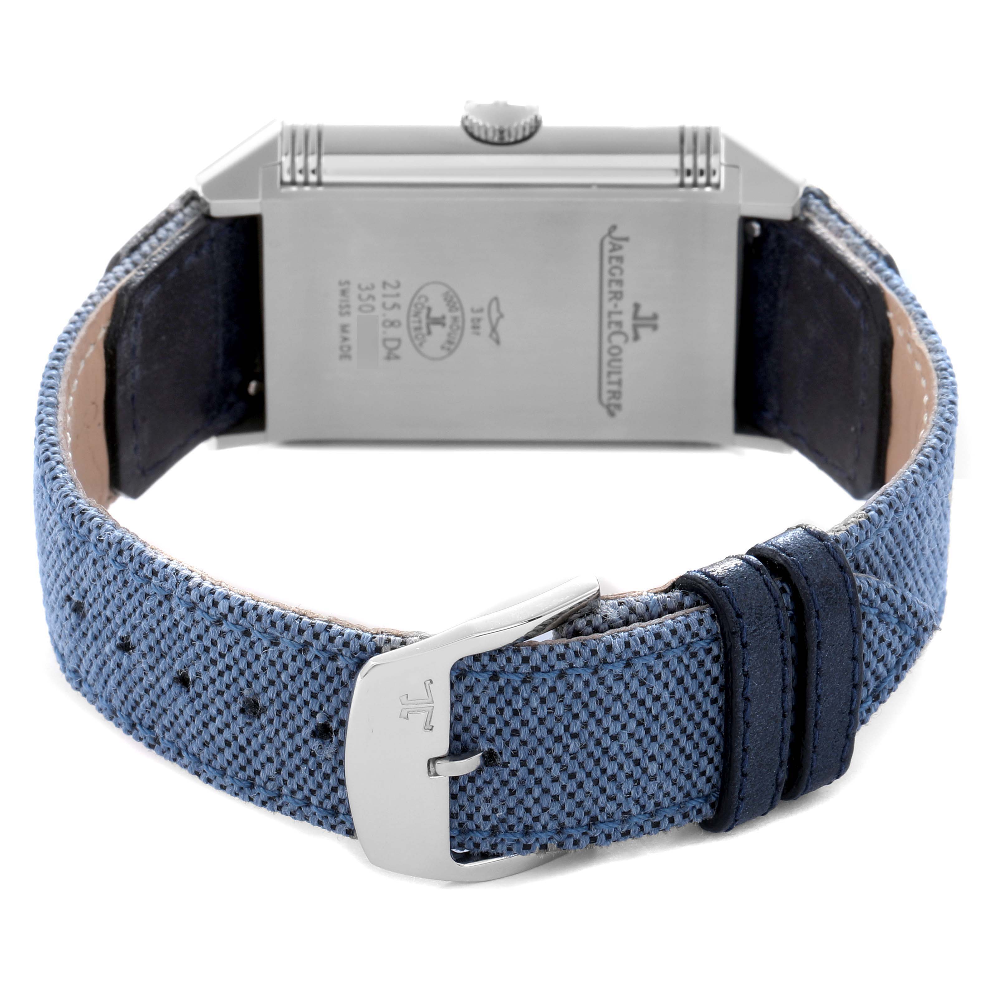 The image shows the back of the Jaeger-LeCoultre Reverso watch, highlighting the case back, crown, and blue strap with a clasp.