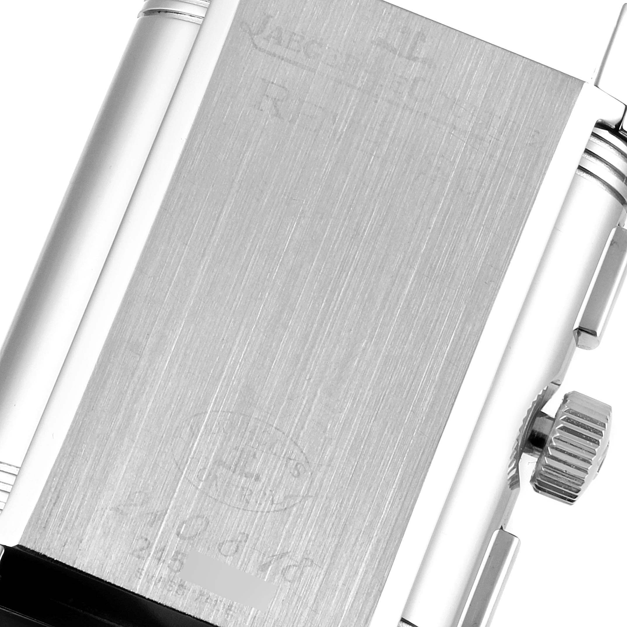 The image shows the back of a Jaeger-LeCoultre Reverso watch, focusing on the case and the crown from a slight top-right angle.