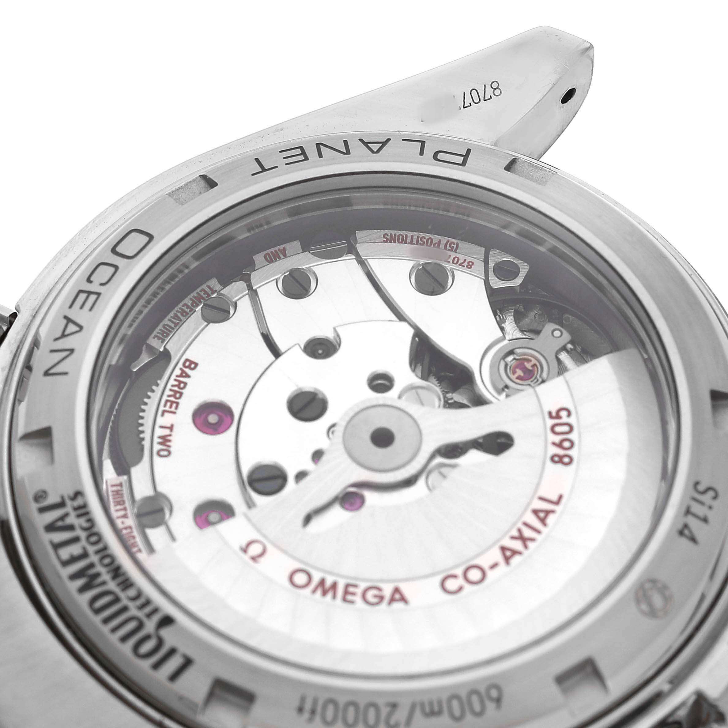 The image shows the transparent case back of an Omega Planet Ocean 232.92.44.22.03.001 Men's Titanium Blue Dial watch, highlighting the Co-Axial movement and inner mechanisms.