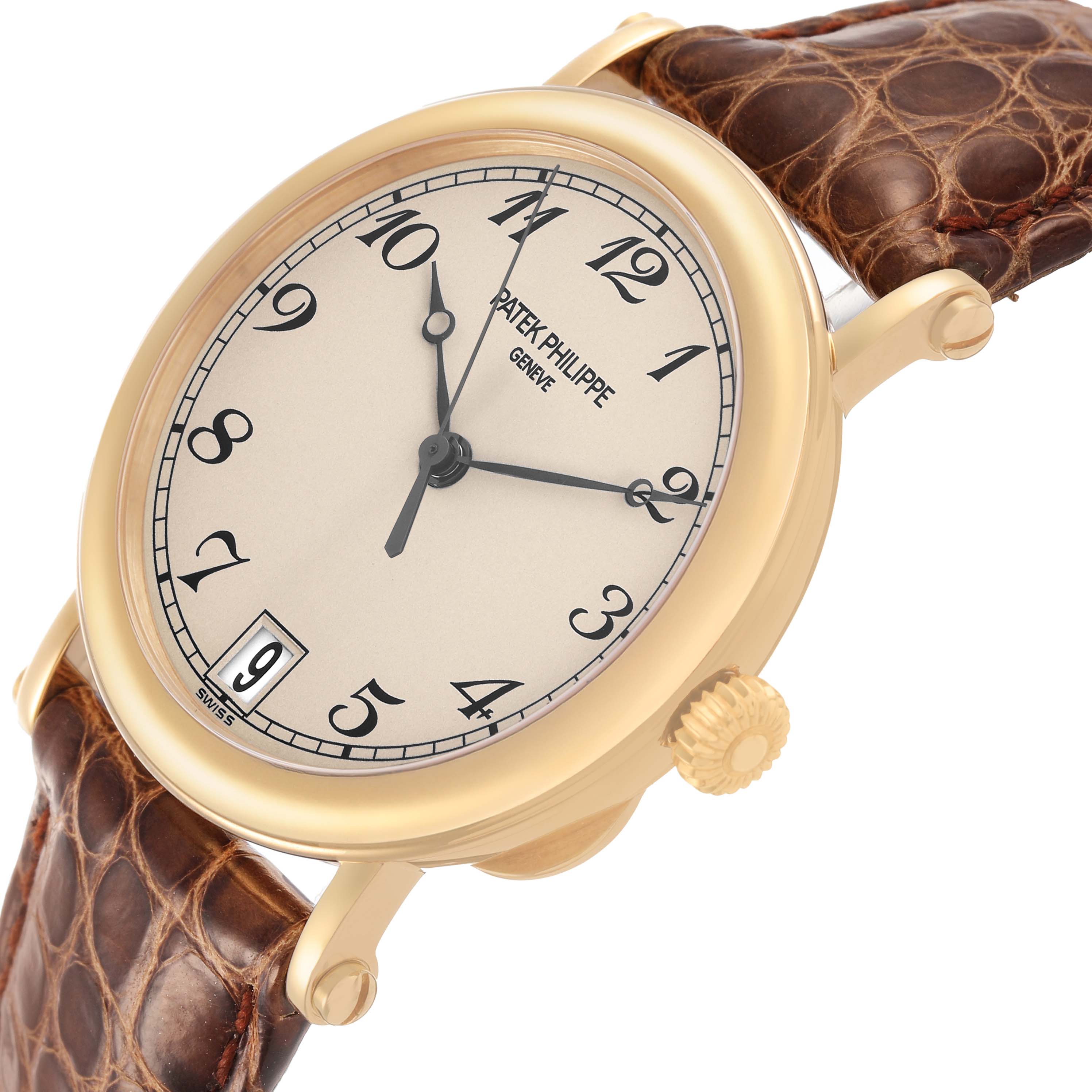 The Patek Philippe Calatrava 5053J Men's Yellow Gold White Dial watch is shown at a three-quarter angle, highlighting the dial, crown, and leather strap.