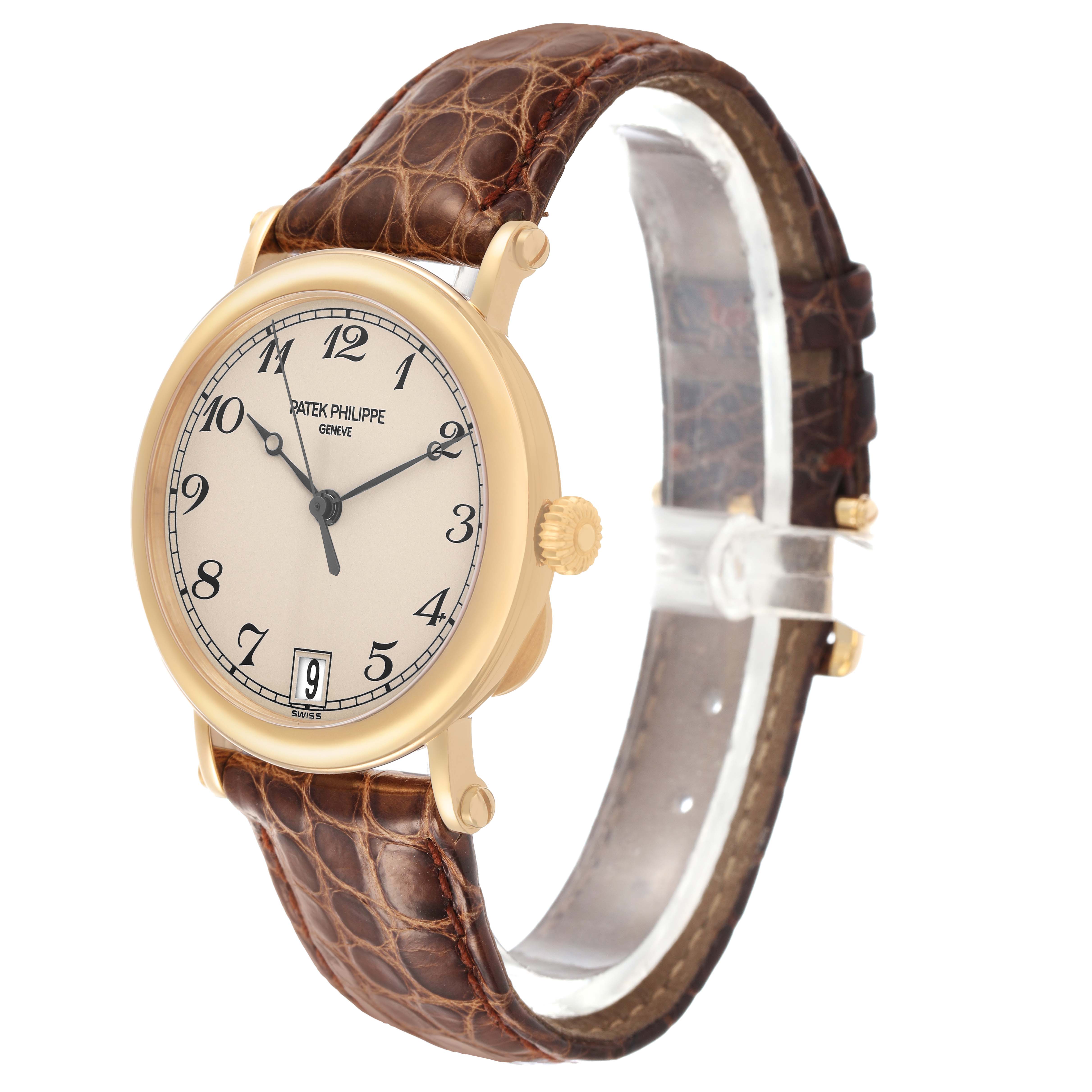 The Patek Philippe Calatrava 5053J Men's Yellow Gold White Dial watch is shown at a three-quarter angle, displaying its dial, crown, and leather strap.