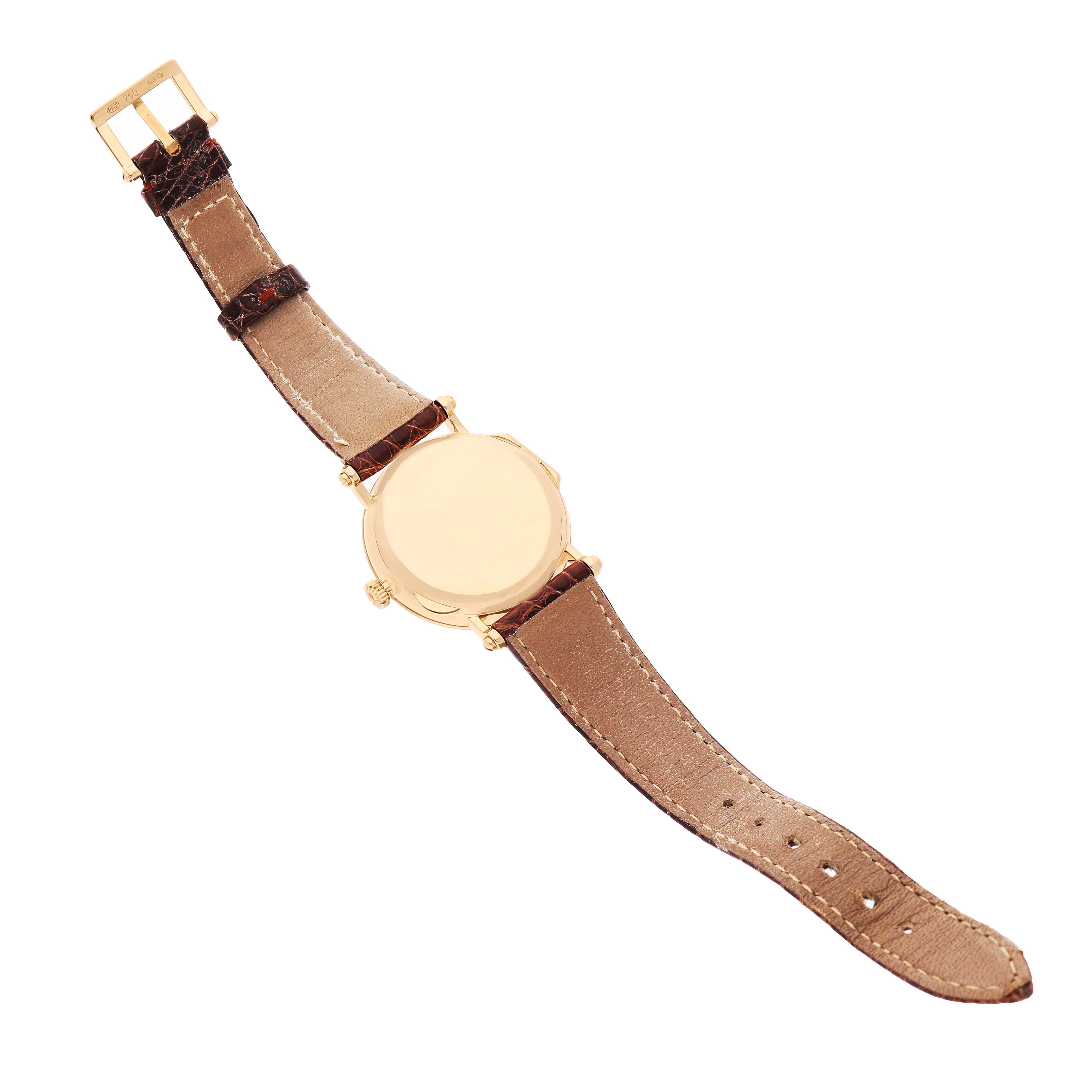 The Patek Philippe Calatrava 5053J Men's Yellow Gold White Dial watch is shown from the back, displaying its leather strap and gold case.