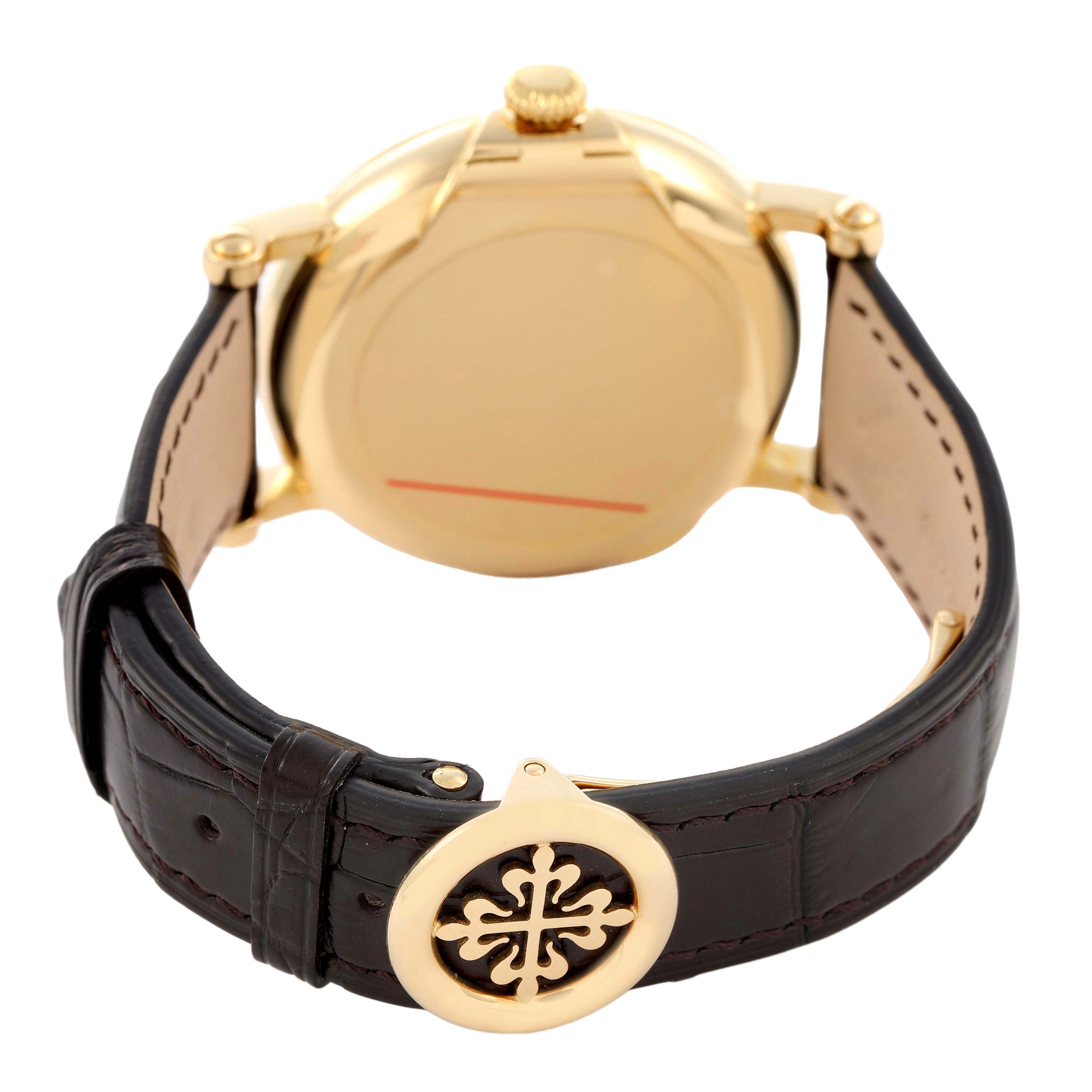 The image shows the back of a Patek Philippe Calatrava 5153J Men's Yellow Gold Silver Dial watch, highlighting the case back, crown, and leather strap with a clasp.
