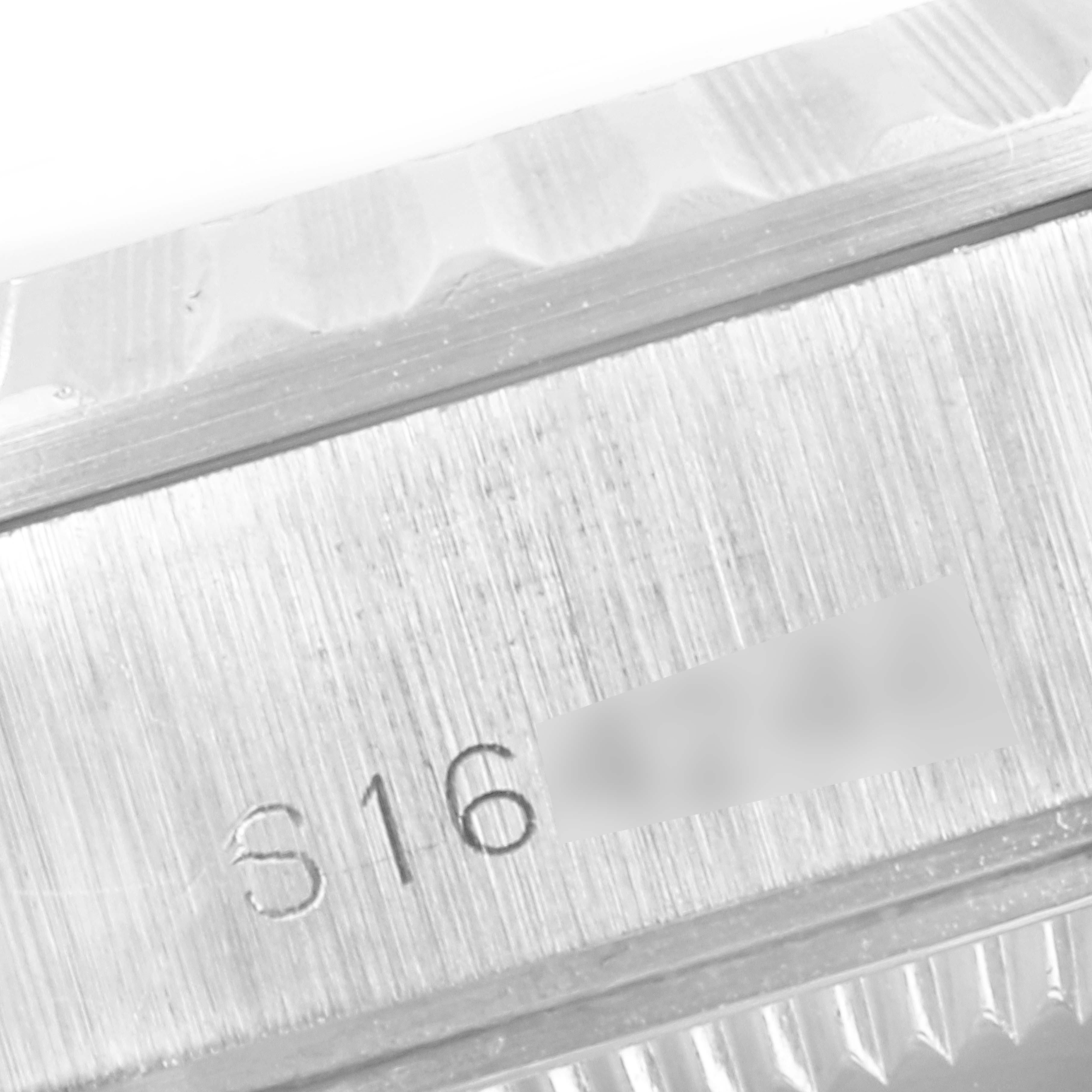 The image shows a close-up view of the engraved serial number and the fluted bezel of a Rolex Date 69240 Women's Stainless Steel Grey Dial 69240 Women's Stainless Steel Grey Dial watch.