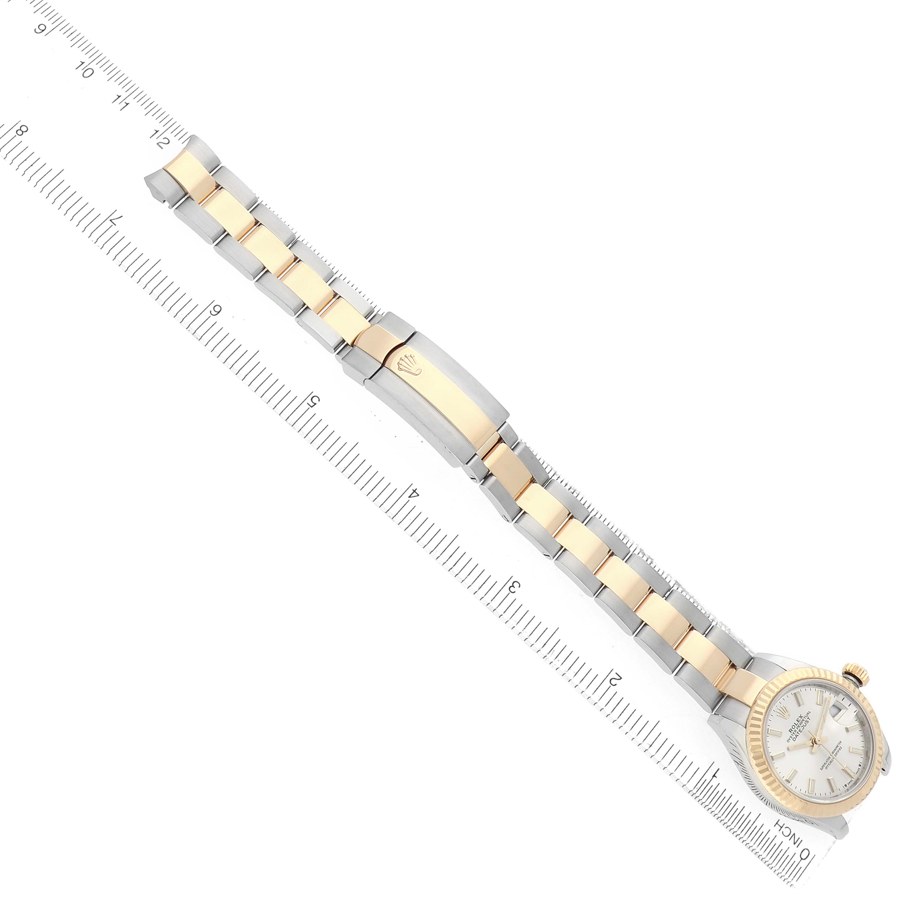 The Rolex Datejust 279173 Women
s Steel and Gold (two tone) Silver Dial watch is shown from a top view, displaying the face, bracelet, and clasp alongside a ruler for scale.