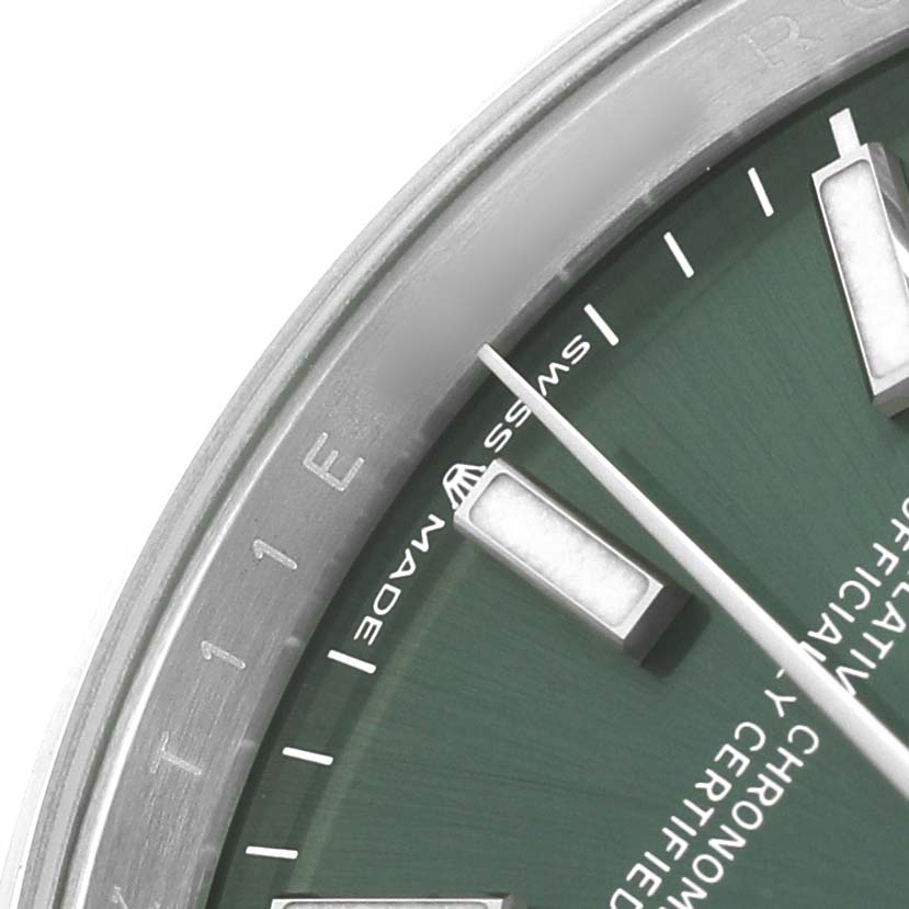 The image shows a close-up of the Rolex Datejust 126200 Men's Stainless Steel Green Dial watch dial, including part of the bezel, markers, and green face.