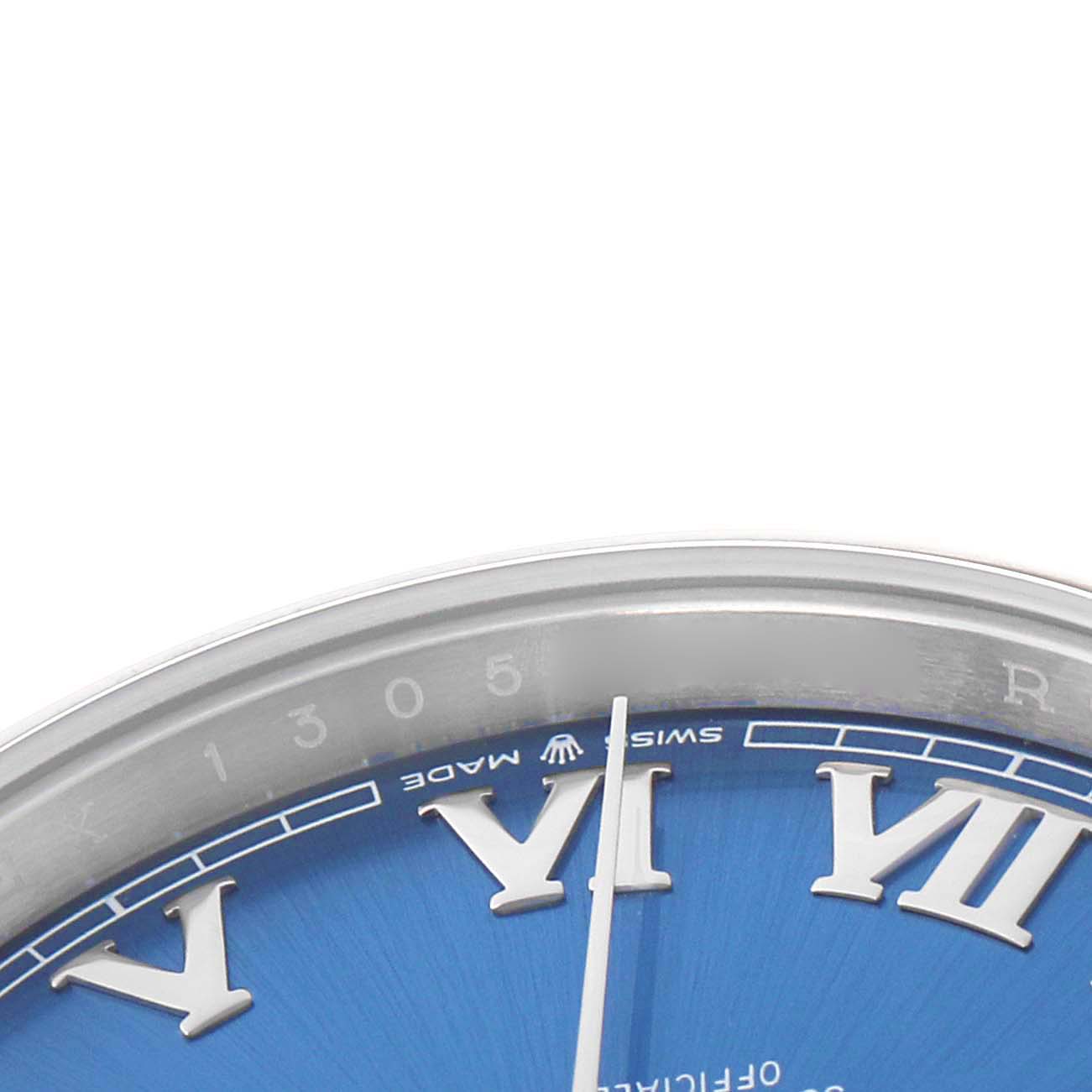 The image shows a close-up of the upper part of the dial of a Rolex Datejust 126300 Men
s Stainless Steel Blue Dial watch, displaying Roman numerals and part of the bezel.