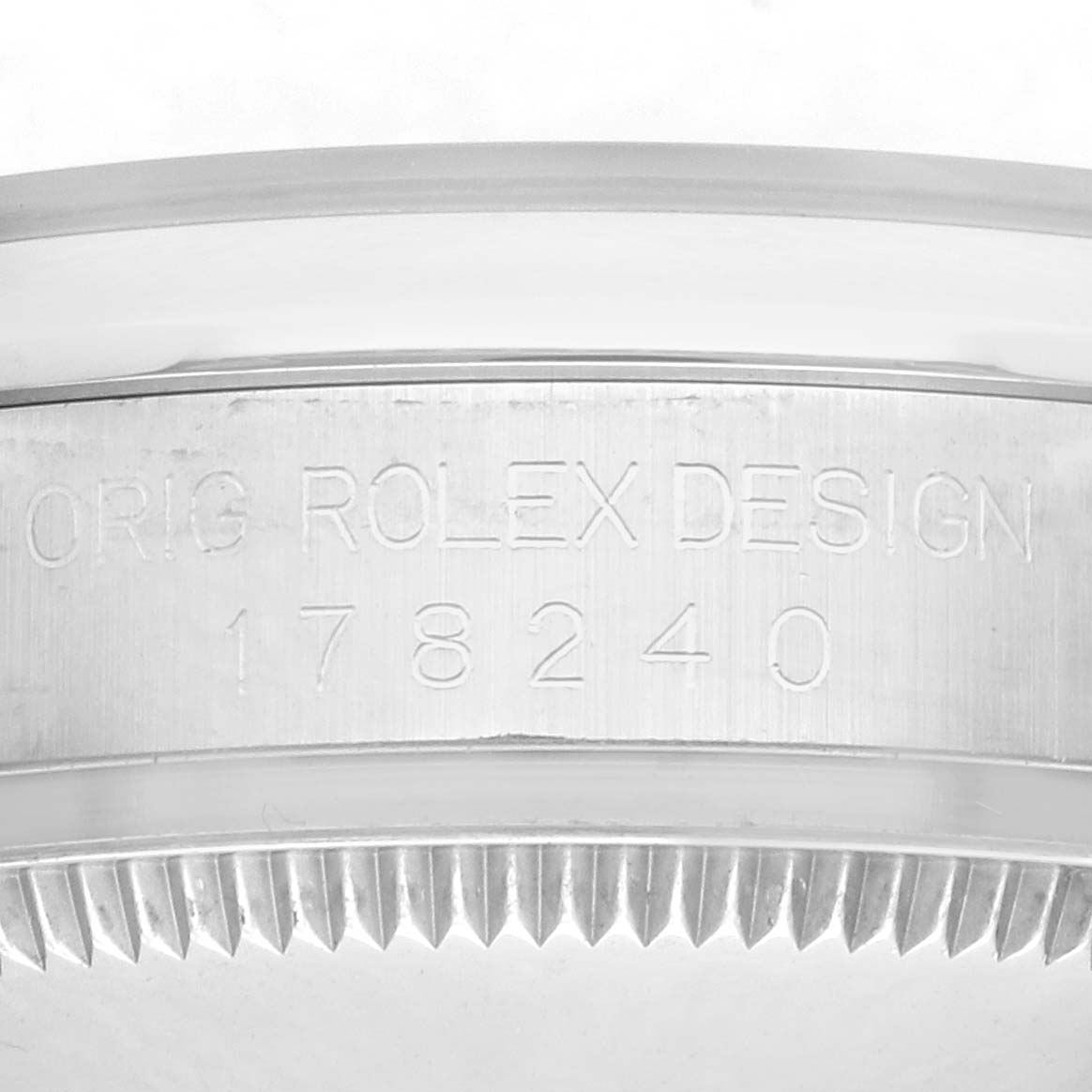 The image shows the side of a Rolex Datejust 178240 Women
s Stainless Steel Pink Dial watch case with engraved text and a notched bezel.