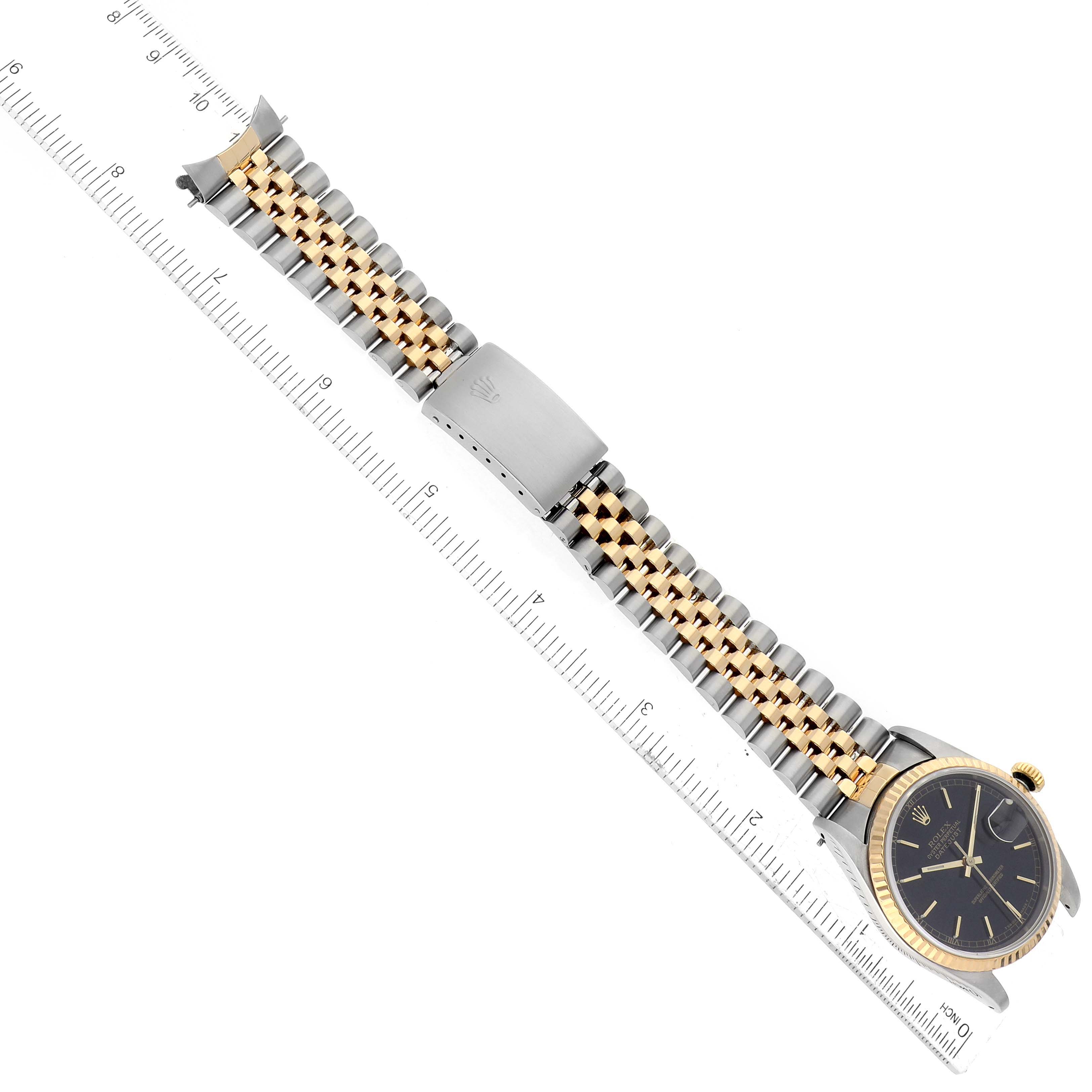 The image shows a Rolex Datejust 16233 Men's Steel and Gold (two tone) Black Dial 16233 Men's Steel and Gold (two tone) Black Dial watch laid flat with a two-tone Jubilee bracelet next to a ruler.