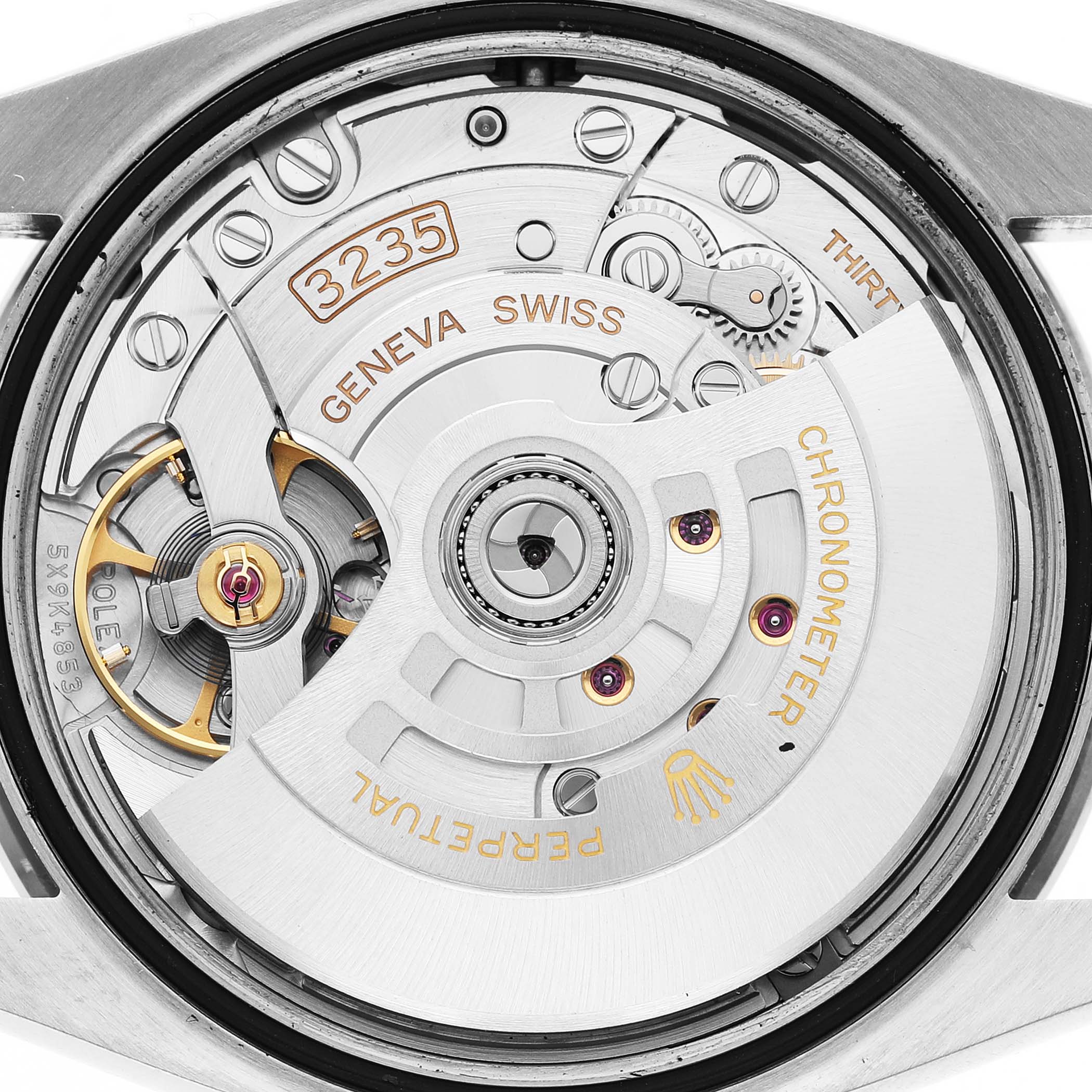 The image shows the movement of a Rolex Datejust 126284 Men's Stainless Steel Blue Dial, highlighting the rotor and intricate internal components from a rear angle.