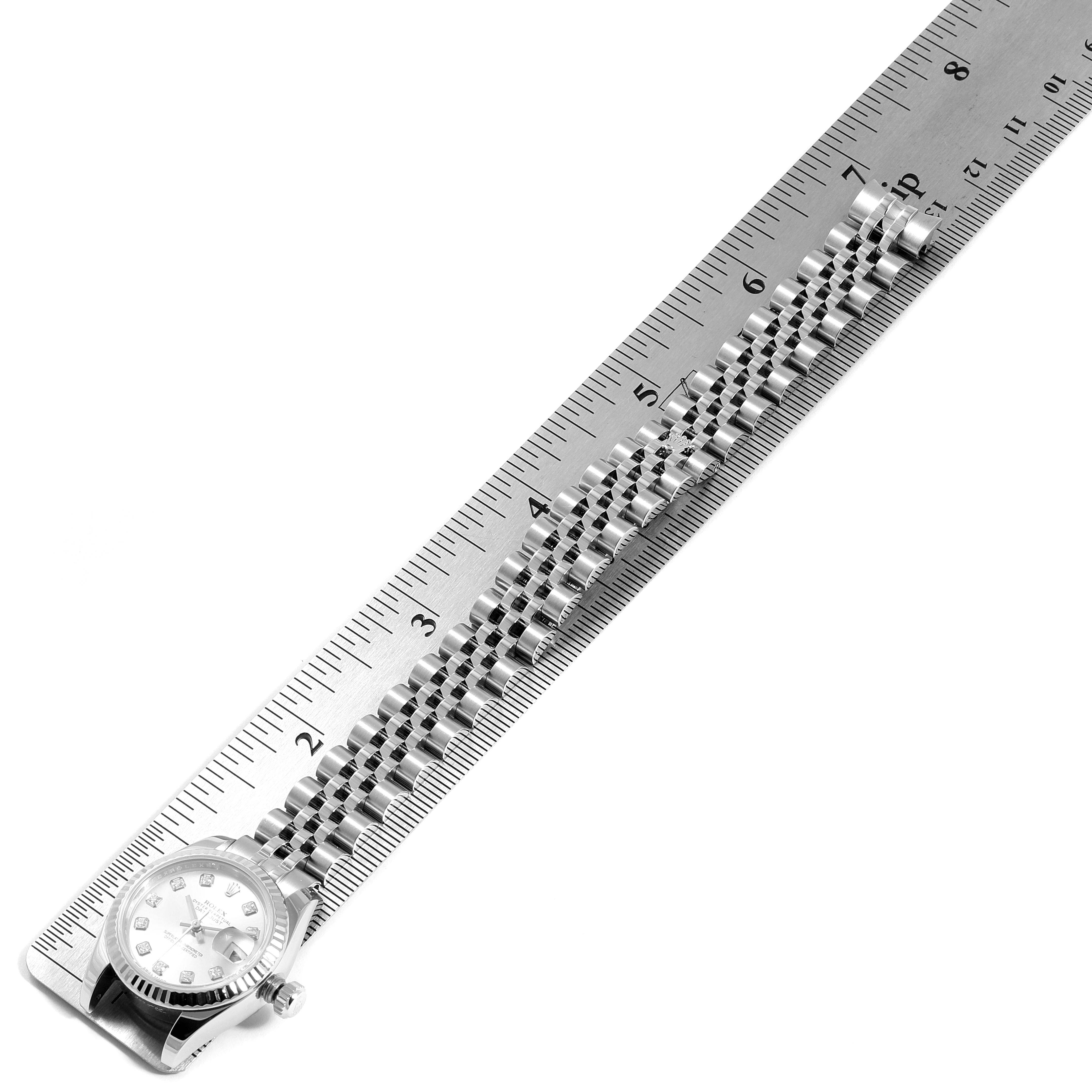 The Rolex Datejust 179174 Women's Stainless Steel Silver Dial 179174 Women's Stainless Steel Silver Dial watch is shown from a top angle, with its bracelet aligned alongside a ruler for measurement.
