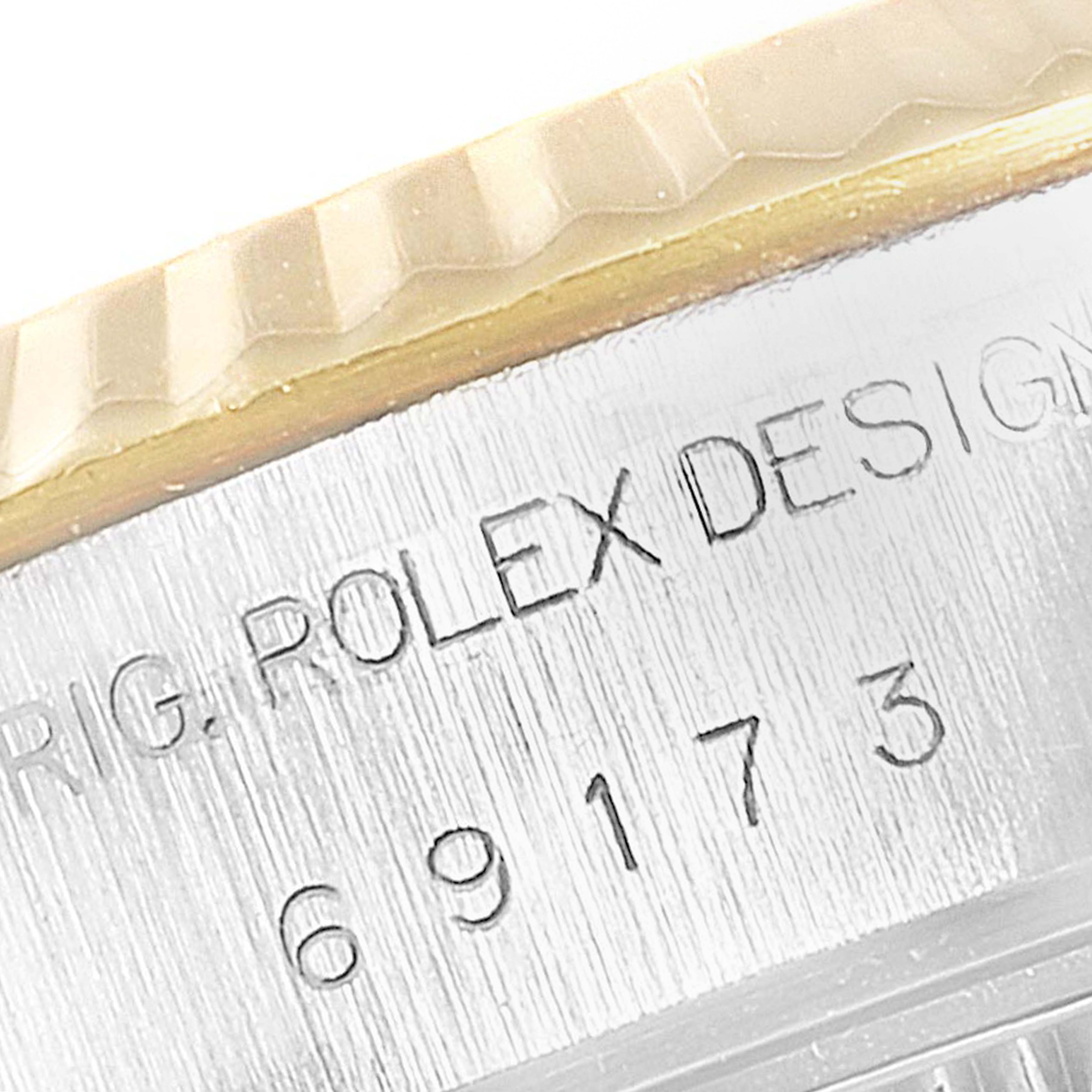 This close-up image of a Rolex Datejust 69173 Women's Steel and Gold (two tone) White Dial 69173 Women's Steel and Gold (two tone) White Dial watch shows the edge of the bezel and the engraved serial number on the case.