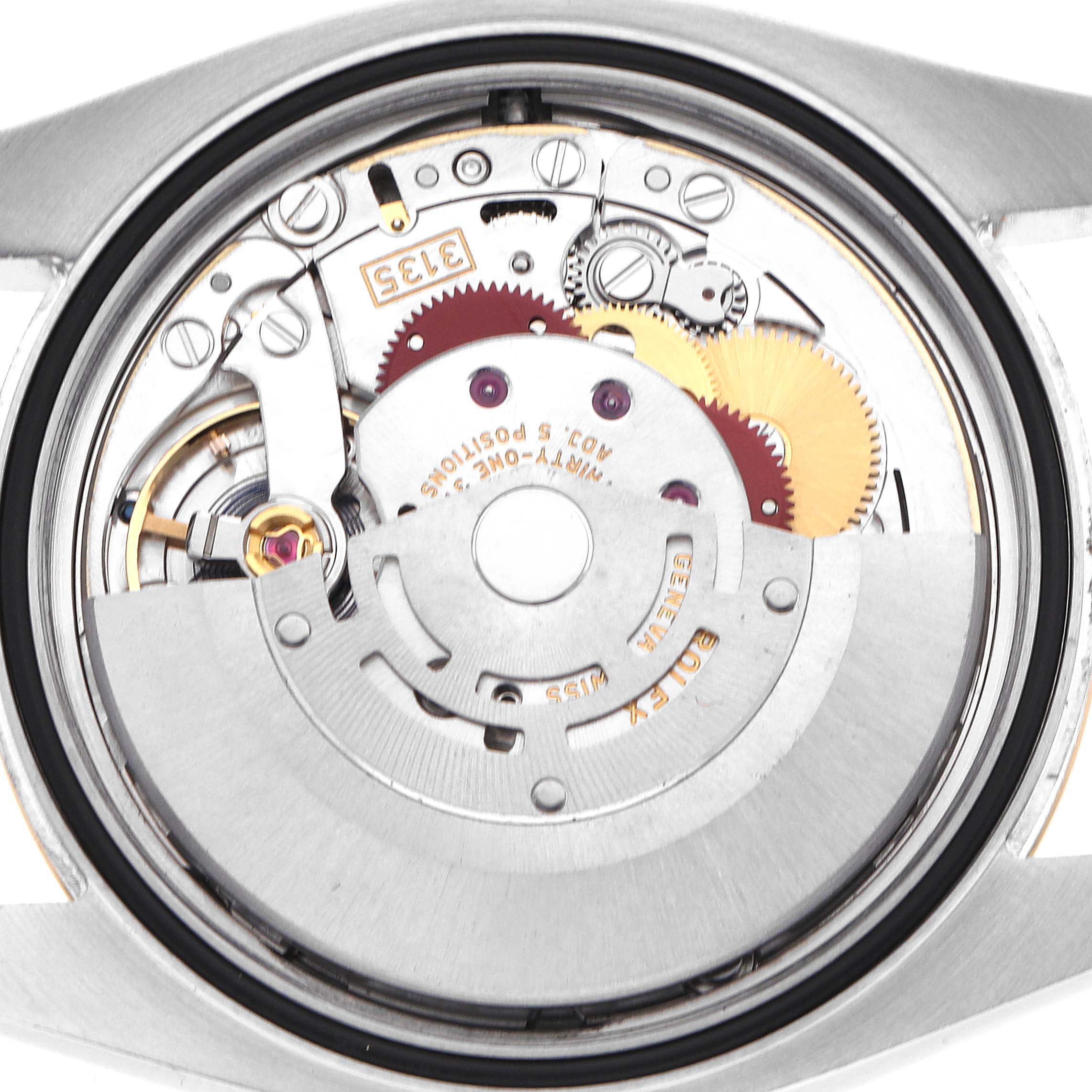 The image shows the movement of a Rolex Datejust 116233 Men
s Steel and Gold (two tone) Silver Dial watch from a close-up angle, highlighting its internal gears and rotor.