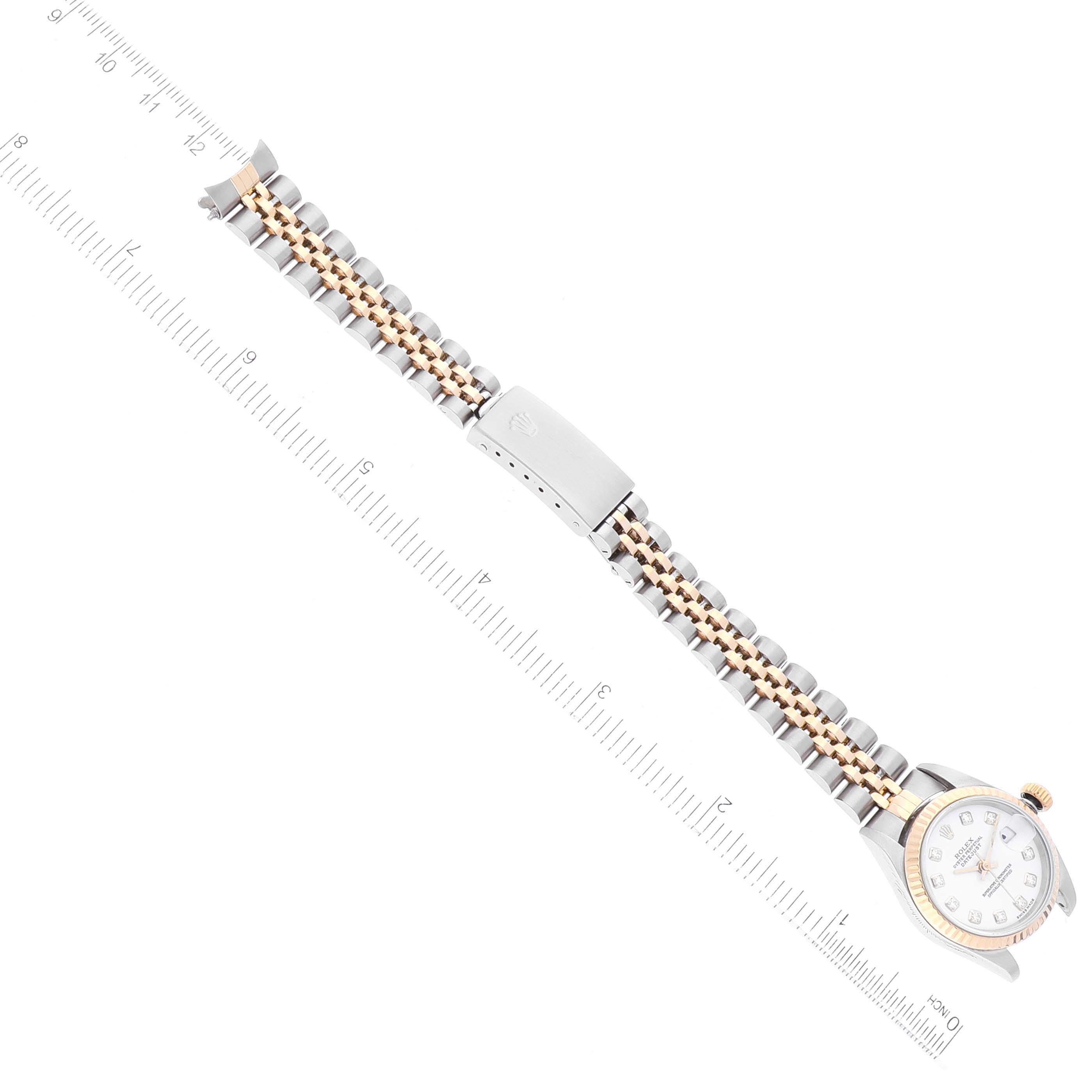 The Rolex Datejust 79173 Women's Steel and Gold (two tone) White Dial 79173 Women's Steel and Gold (two tone) White Dial watch is shown from a top-down angle, displaying the face, bracelet, and clasp with a ruler for scale.