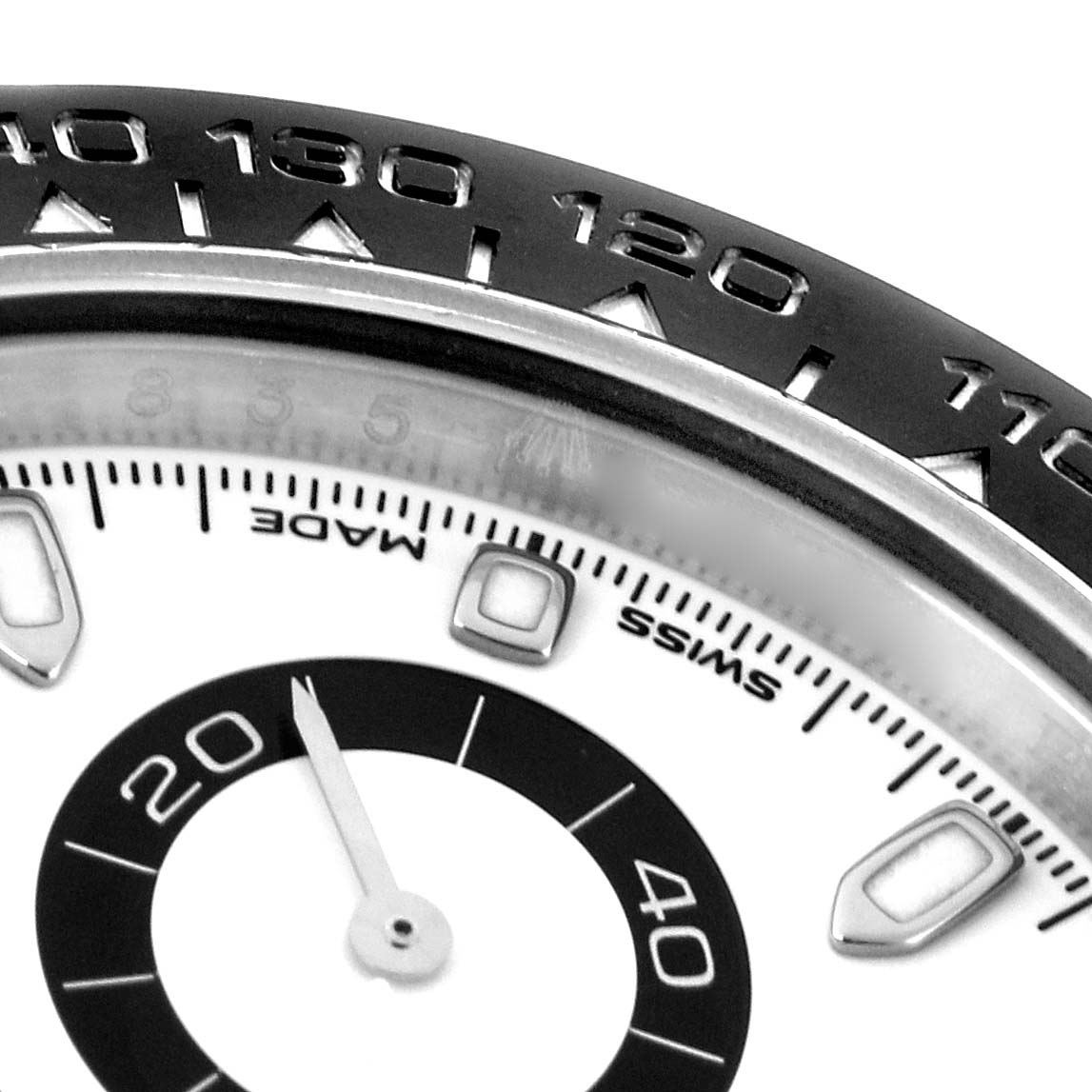The image shows a close-up of the Rolex Daytona 116500 Men
s Stainless Steel White Dial
s bezel and part of the dial, highlighting the tachymetric scale and sub-dial.