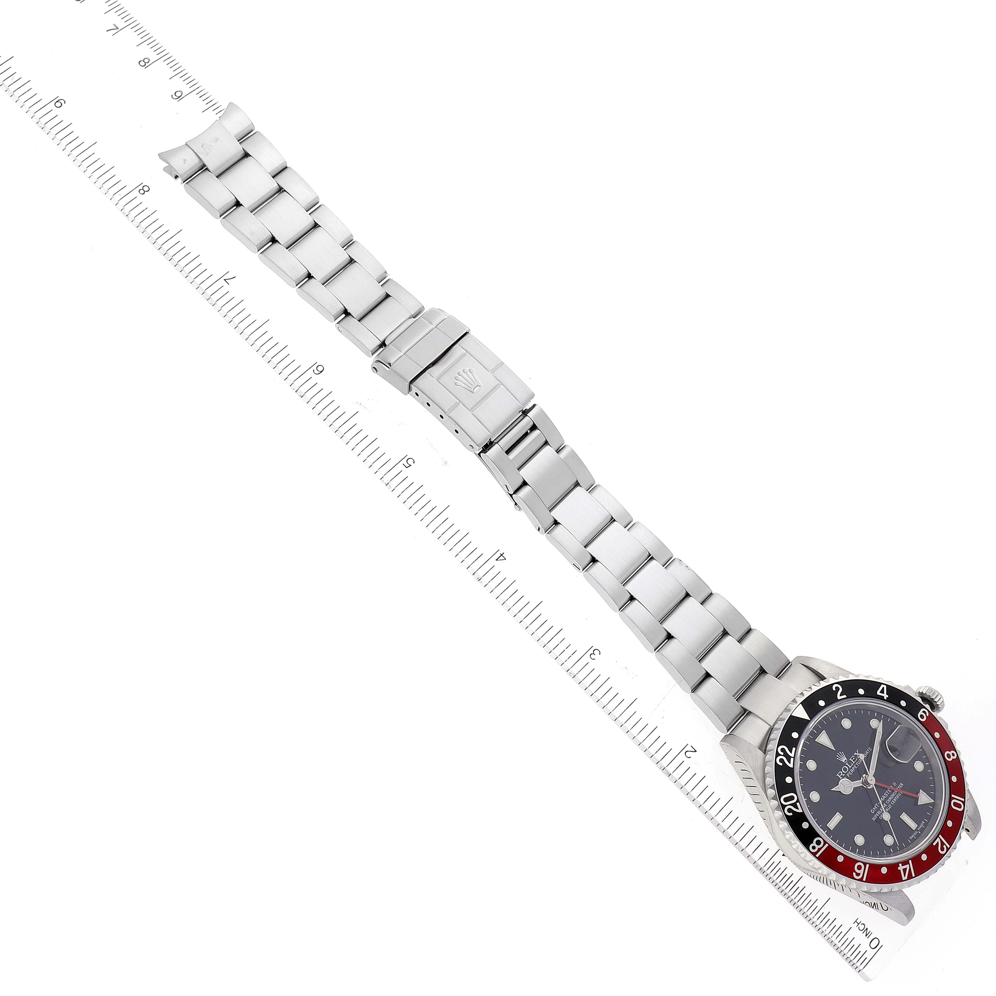 The image shows a Rolex GMT-Master 16710 Men's Stainless Steel Black Dial 16710 Men's Stainless Steel Black Dial watch at a diagonal angle with its strap fully extended alongside a ruler.