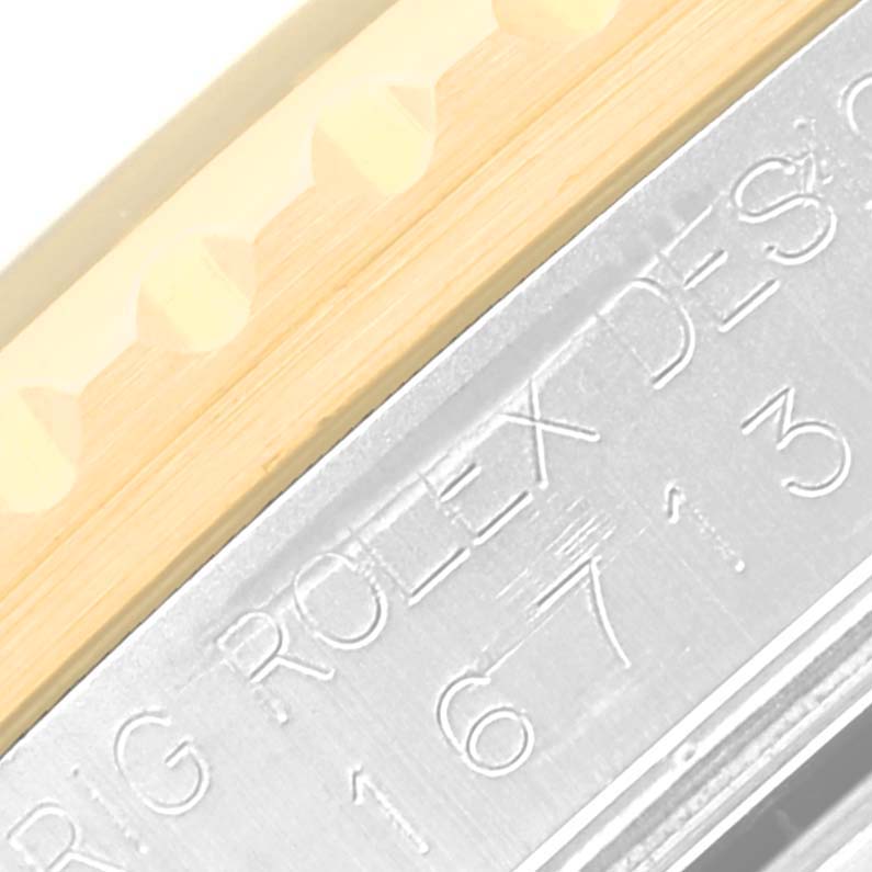 This image shows a close-up of the case and bezel of a Rolex GMT-Master 16713 Men's Steel and Gold (two tone) Black Dial 16713 Men's Steel and Gold (two tone) Black Dial watch.